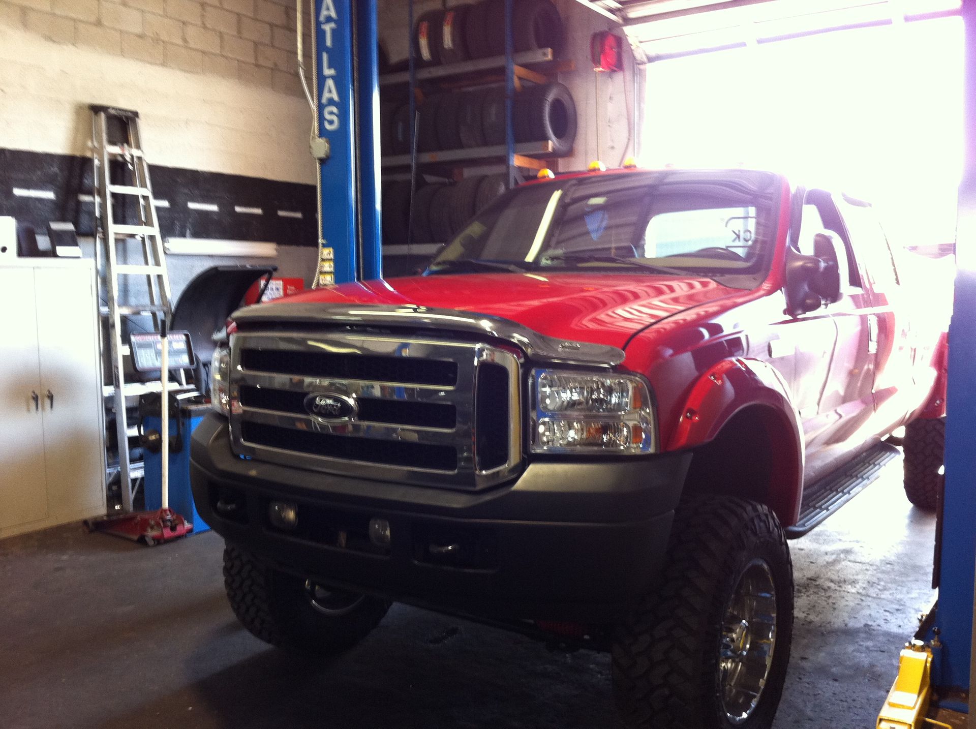 A red truck is sitting on a lift that says atlas