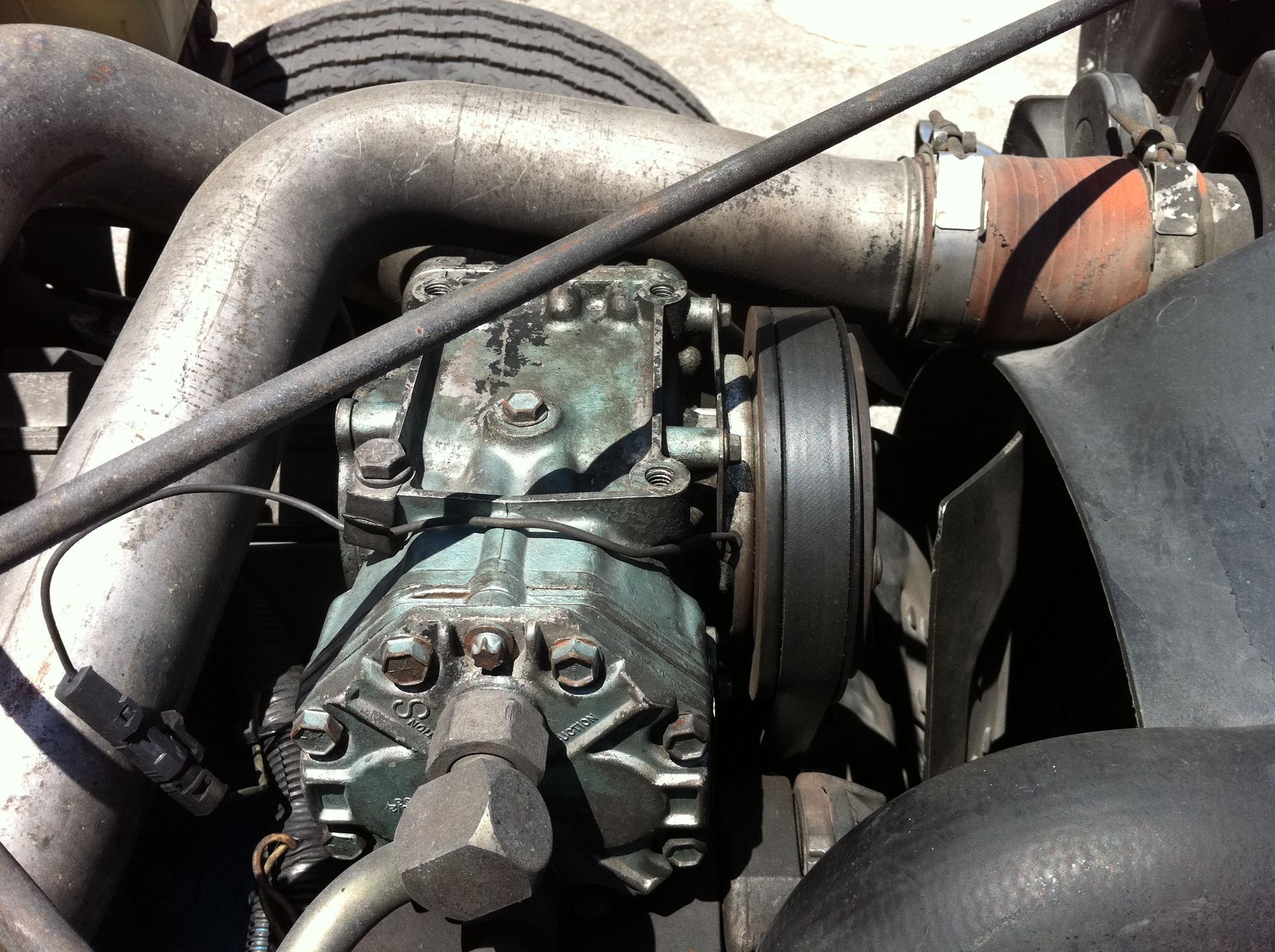 A close up of a car engine with a hose coming out of it