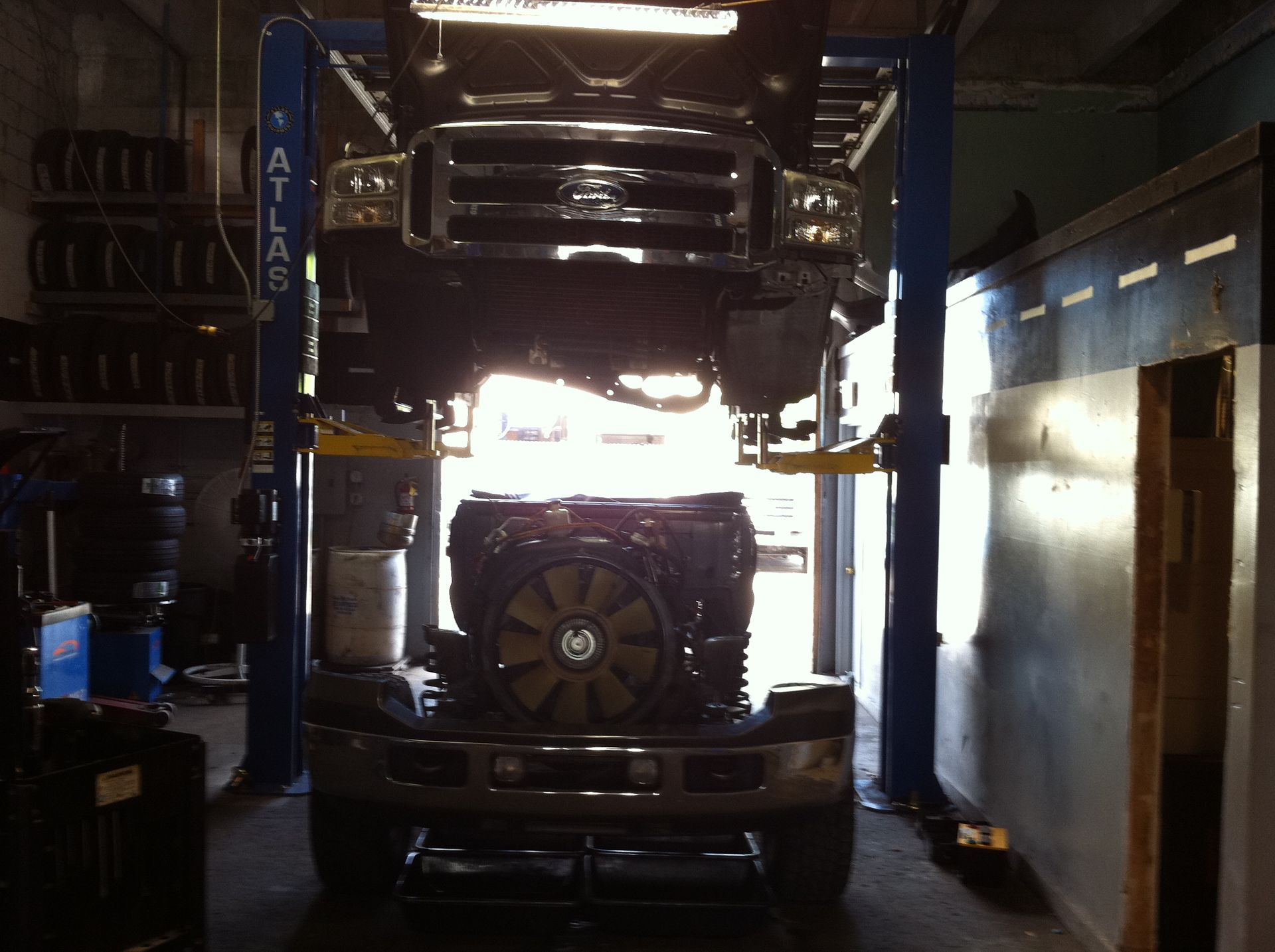 A ford truck is on a lift in a garage