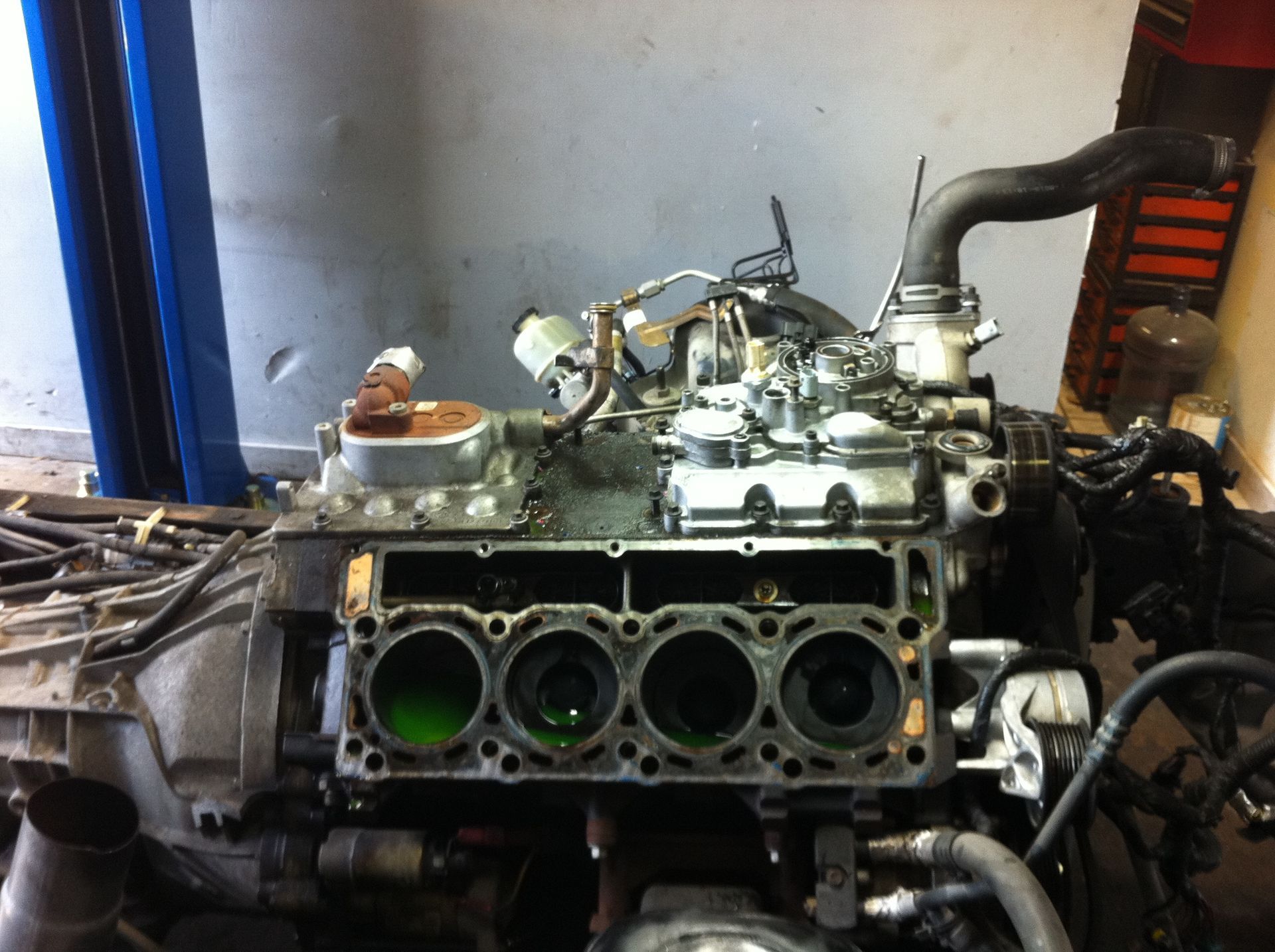 A close up of a car engine with a green liquid coming out of it