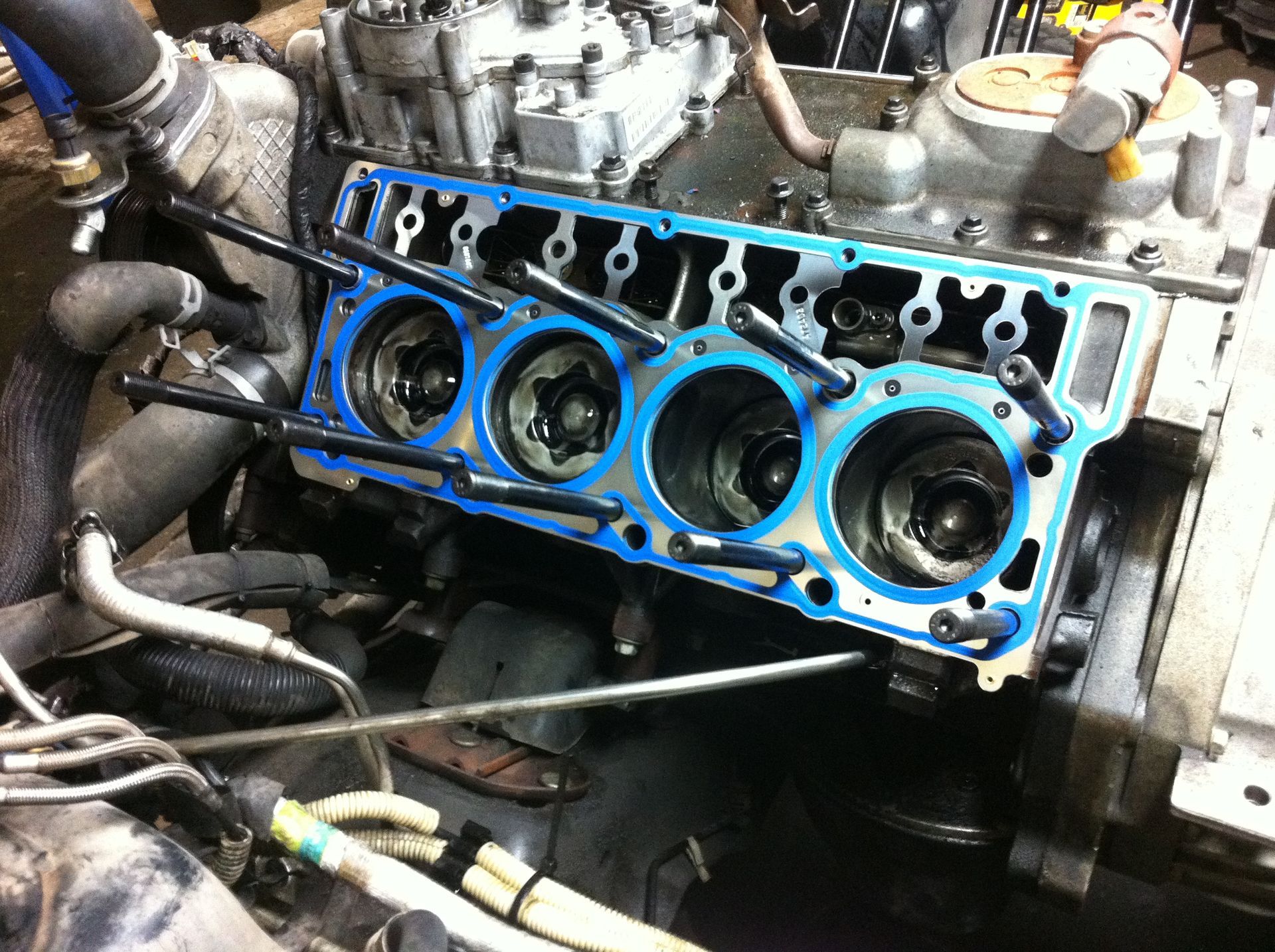 A close up of a car engine with a blue head gasket