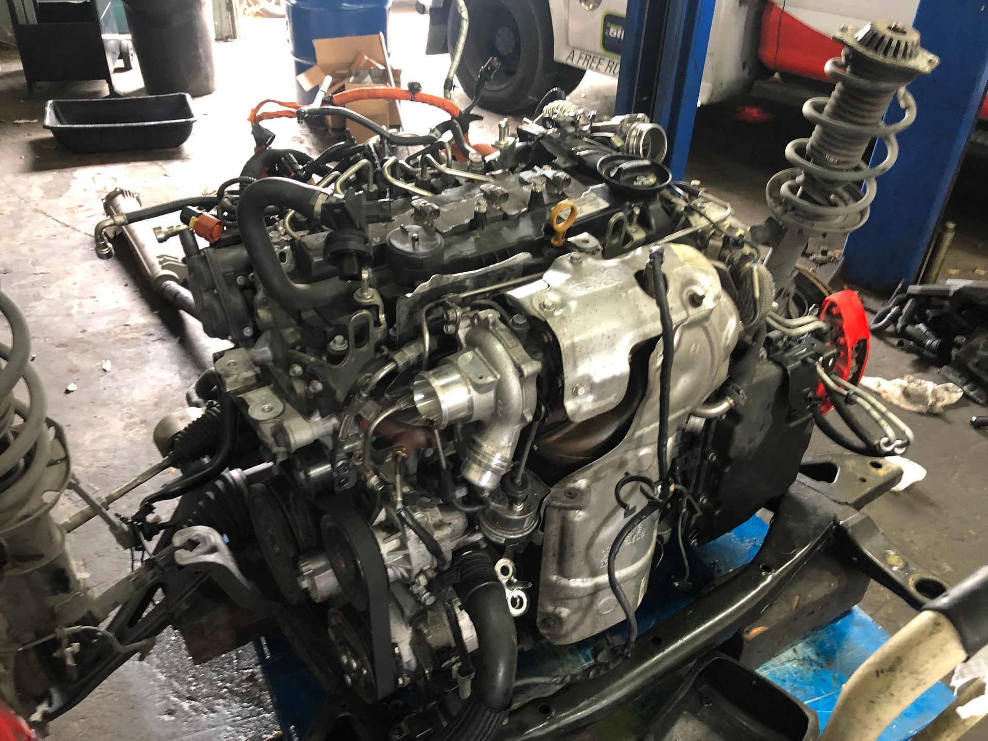 A car engine is sitting on top of a table in a garage.