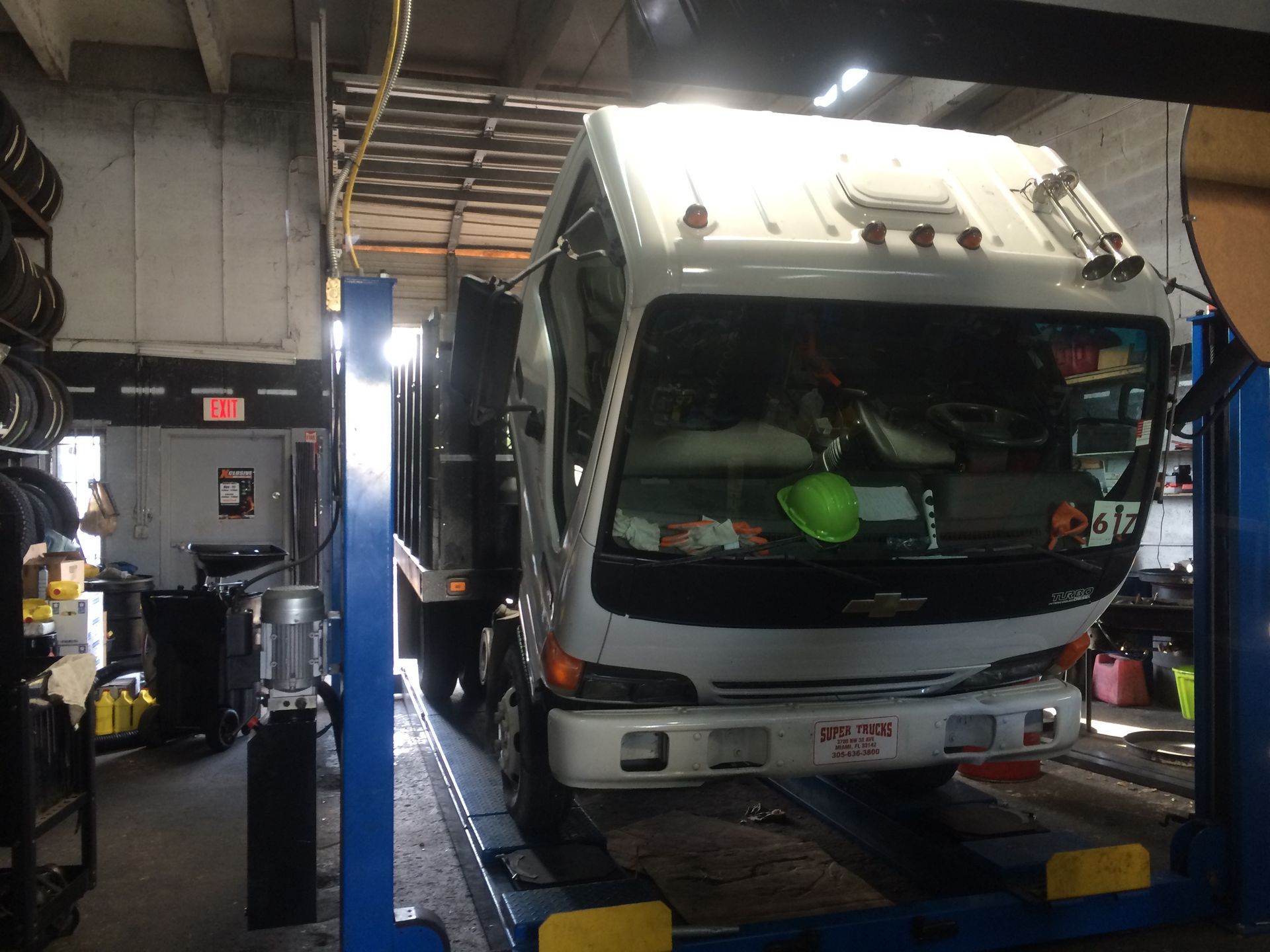 A white truck is sitting on a lift in a garage