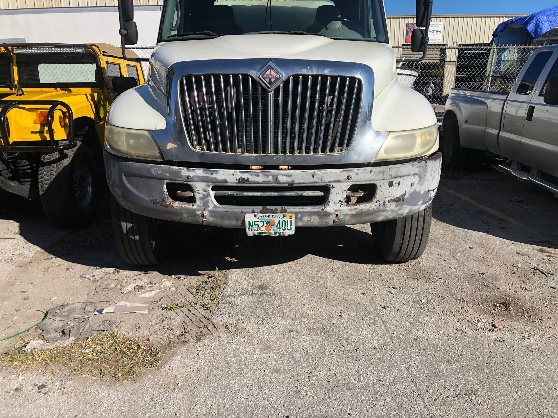 A white truck with a florida license plate is parked in a parking lot.