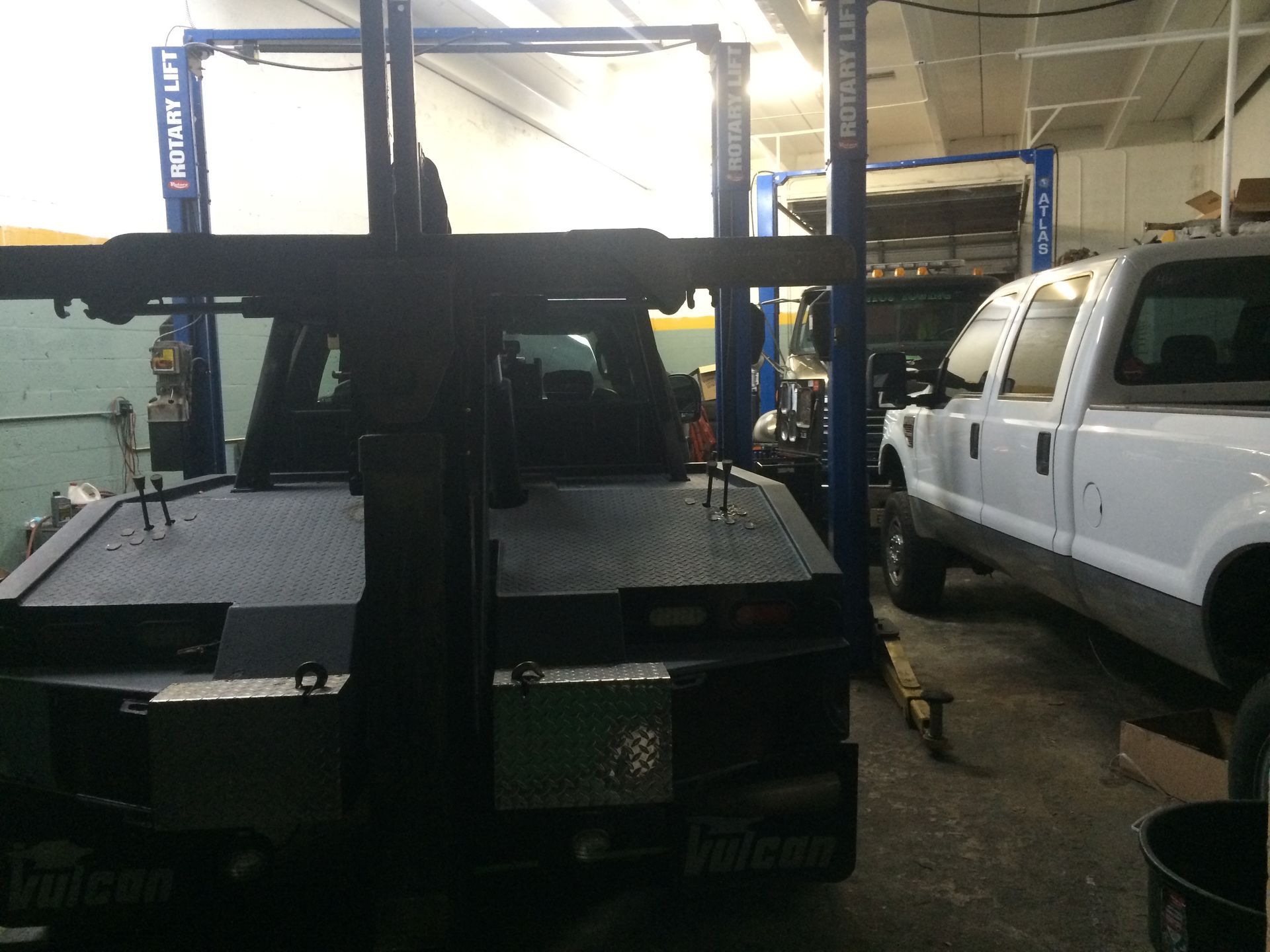 A white truck is sitting on a lift in a garage