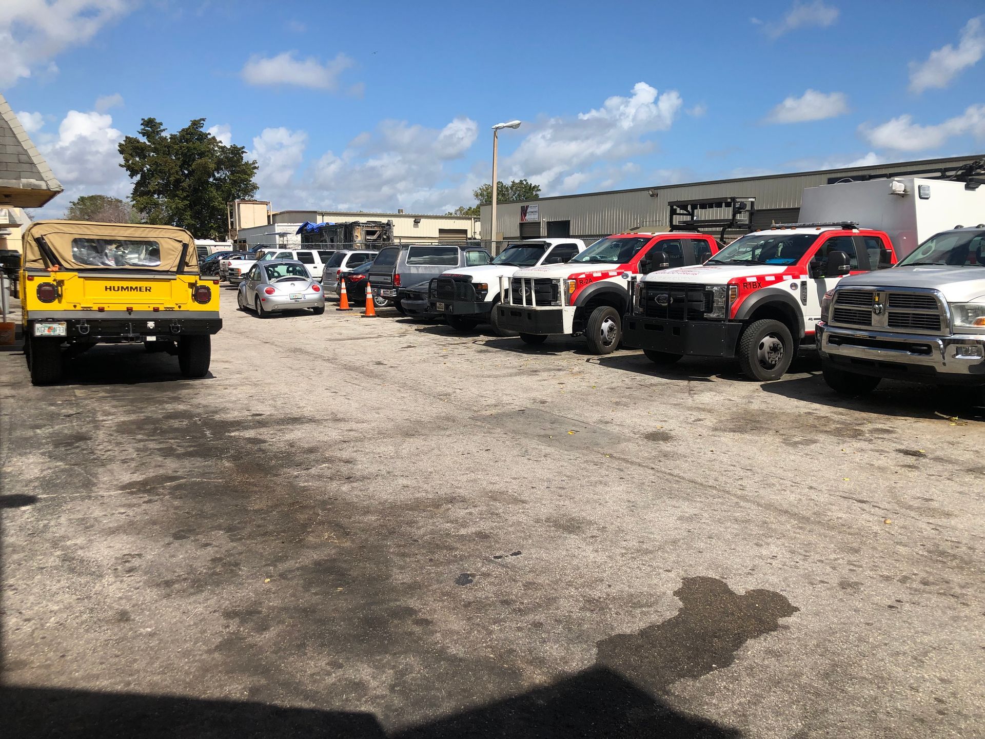 A row of tow trucks are parked in a parking lot.