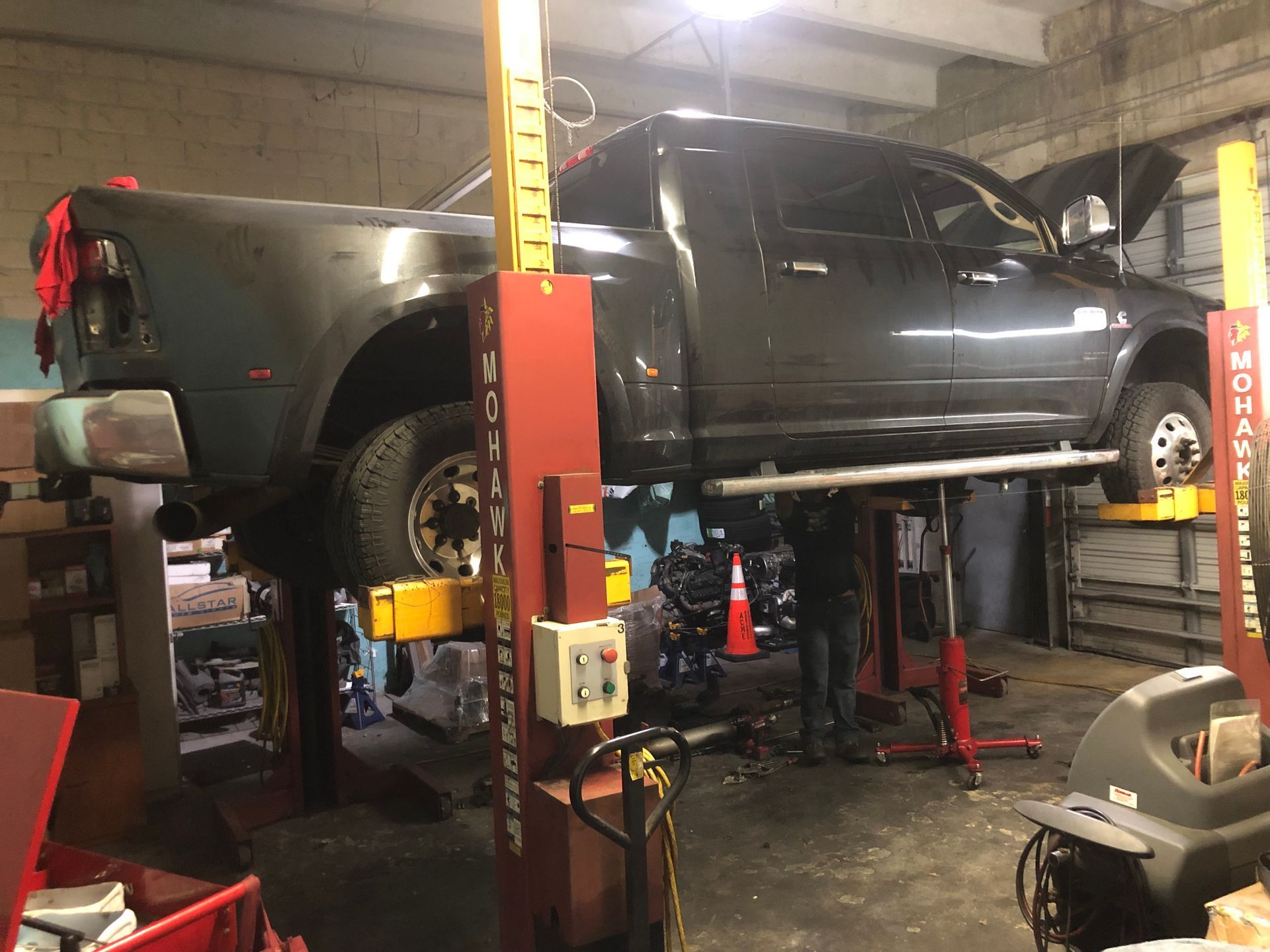 A truck is sitting on a lift in a garage.