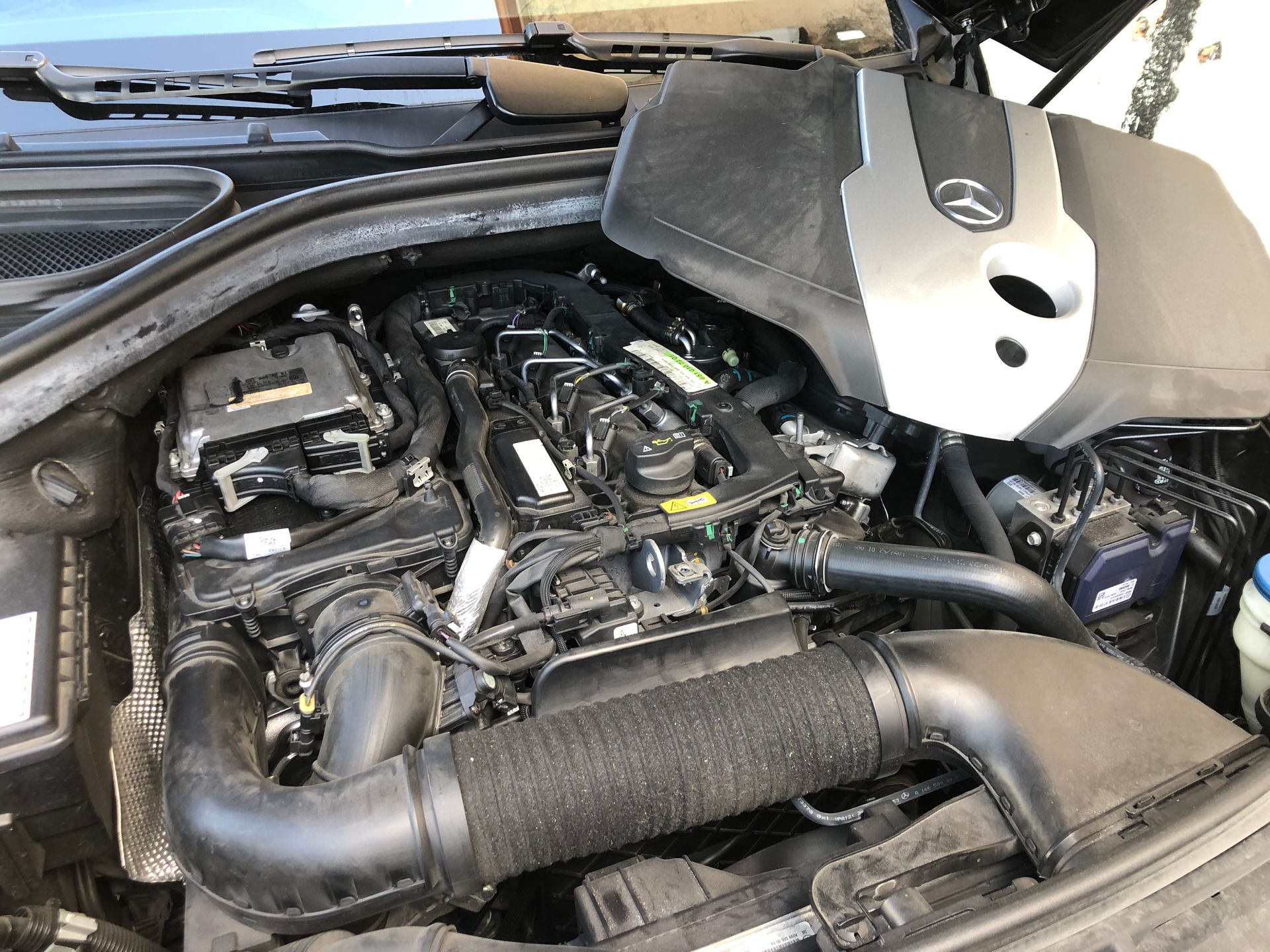 A close up of a car engine with the hood up.