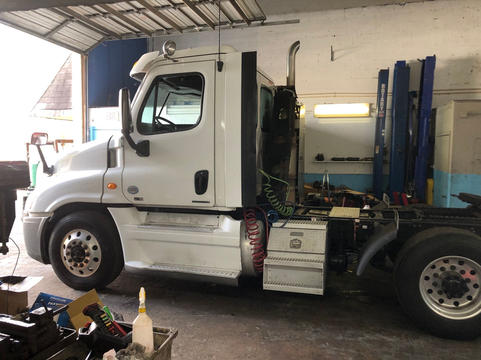 A white semi truck is parked in a garage.