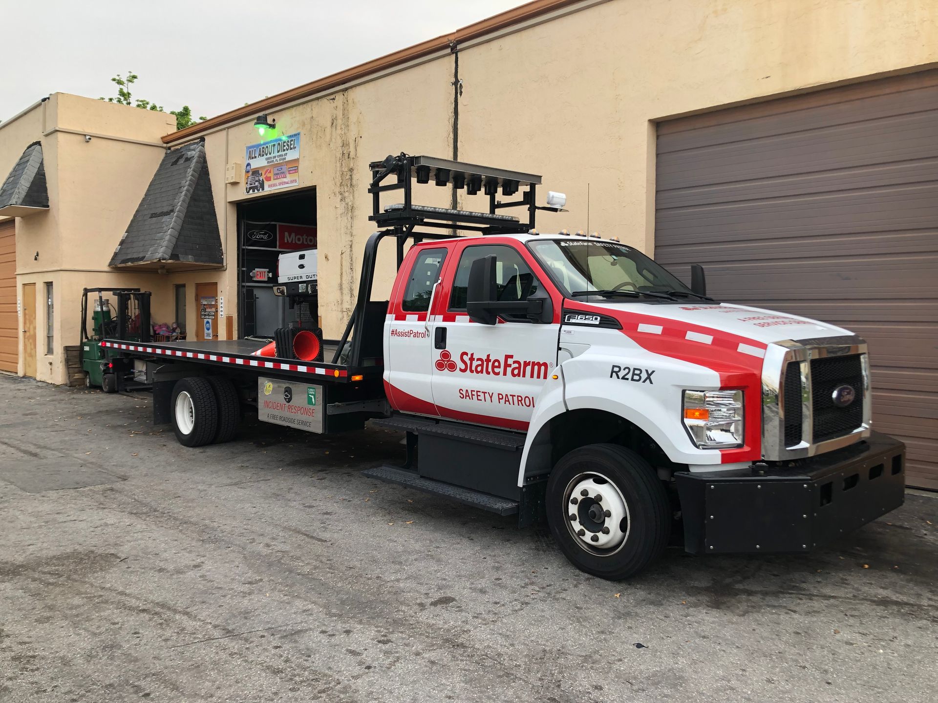 A red and white tow truck is parked in front of a building.