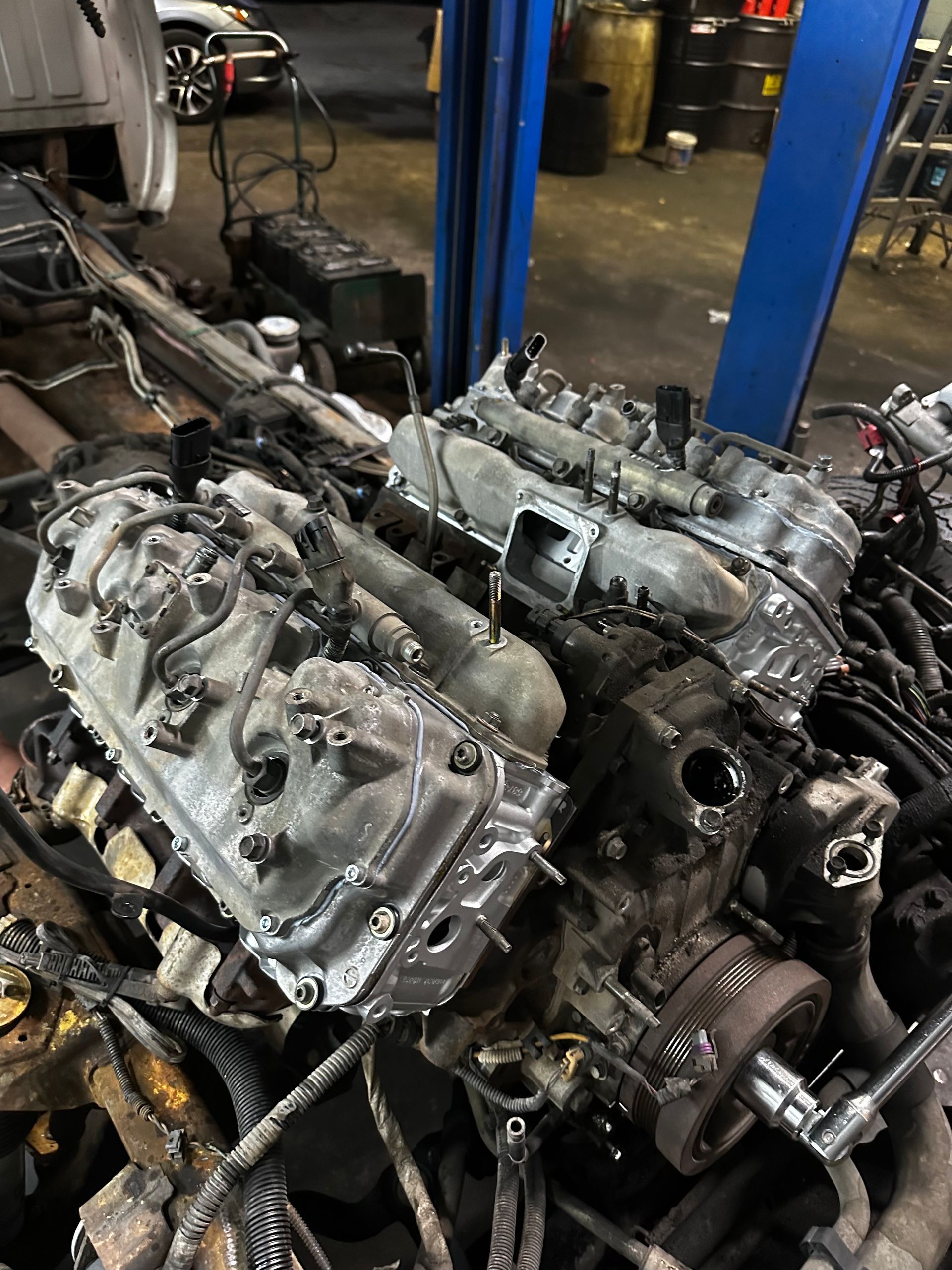 A car engine is being dismantled in a garage.