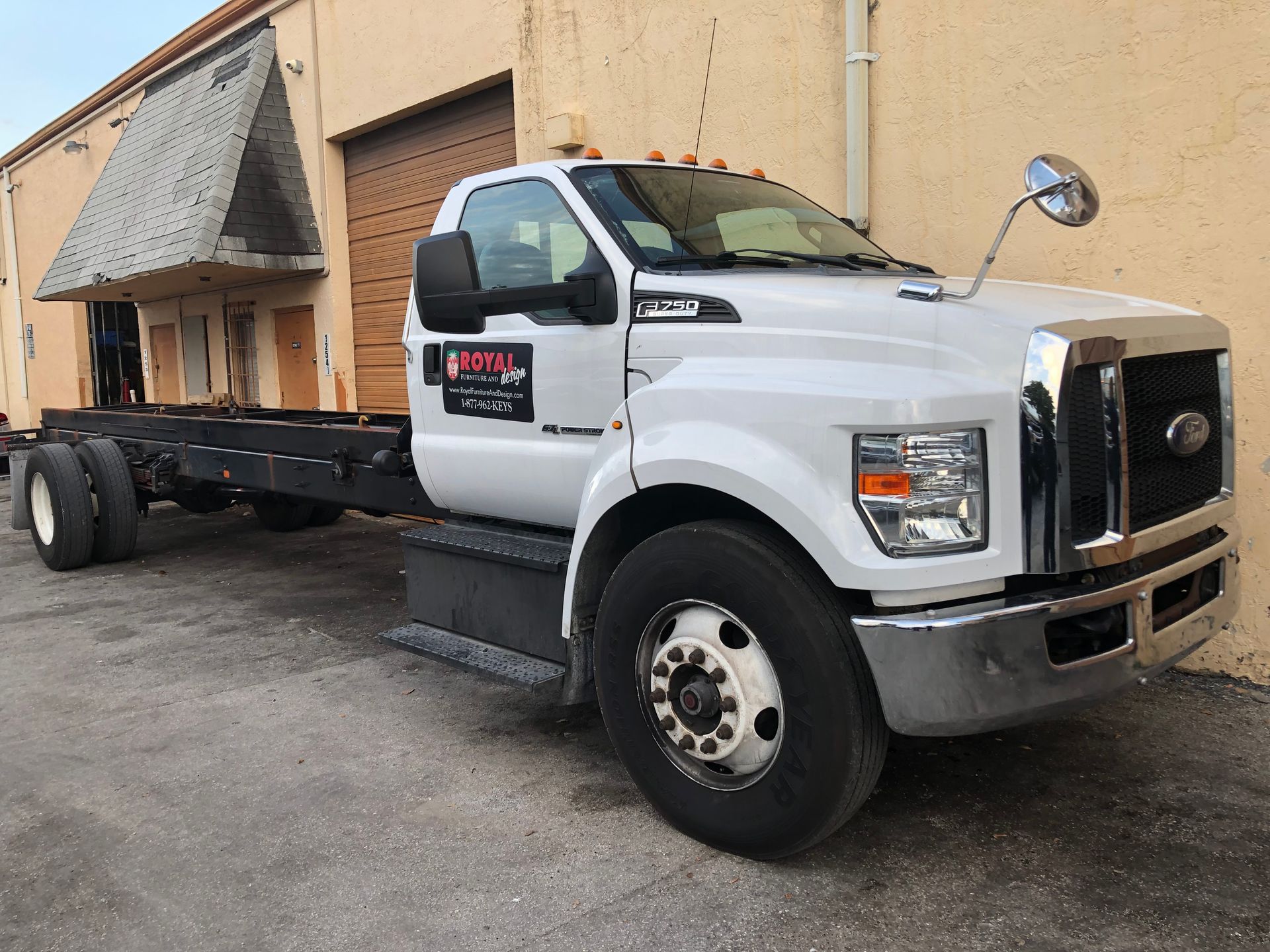 A white truck is parked in front of a building.