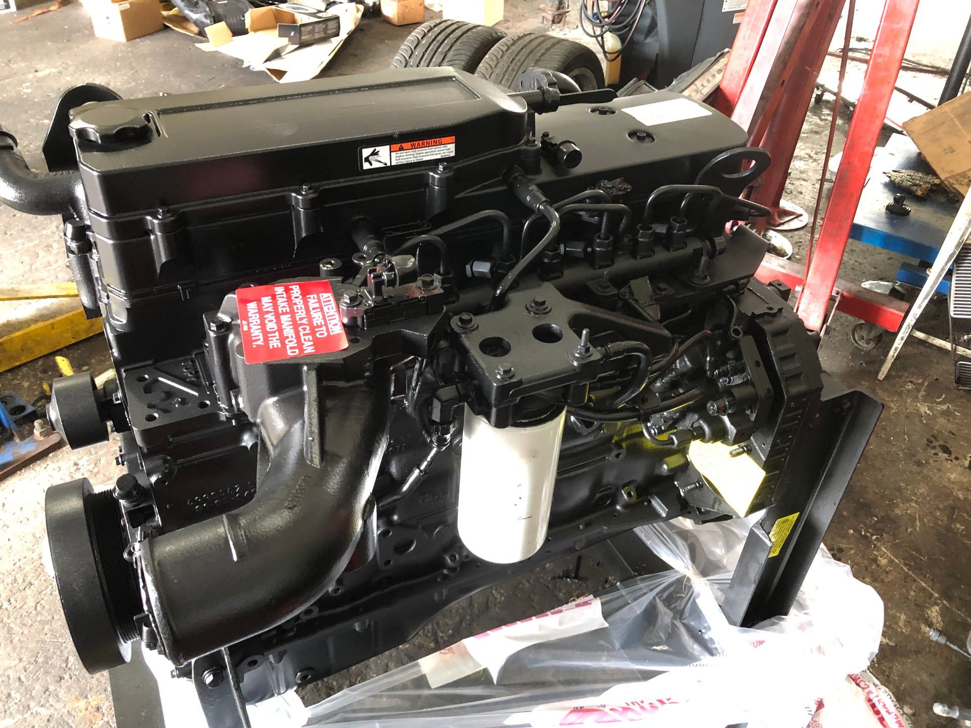 A black engine is sitting on top of a table in a garage.