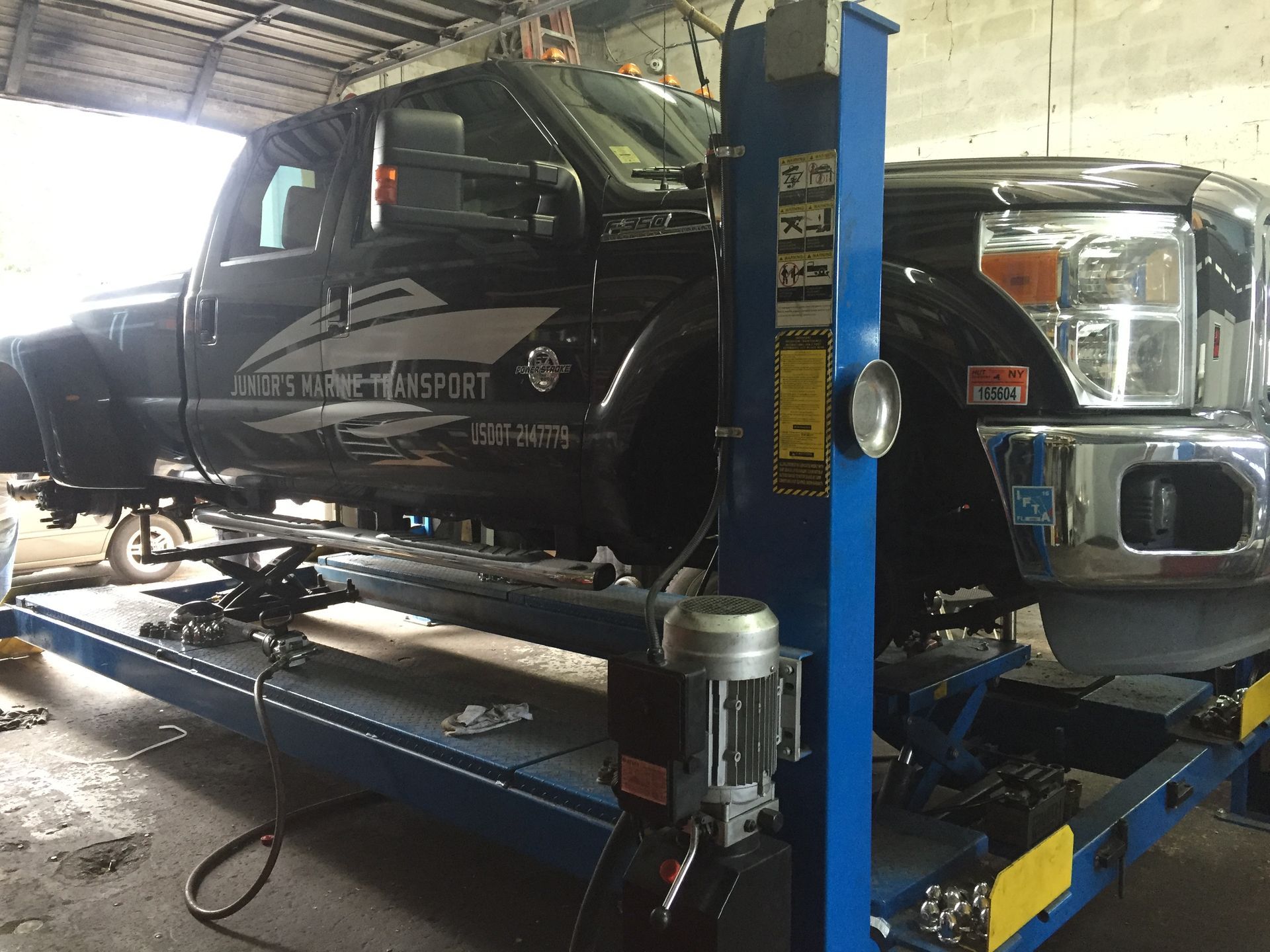 A truck is sitting on a lift in a garage.