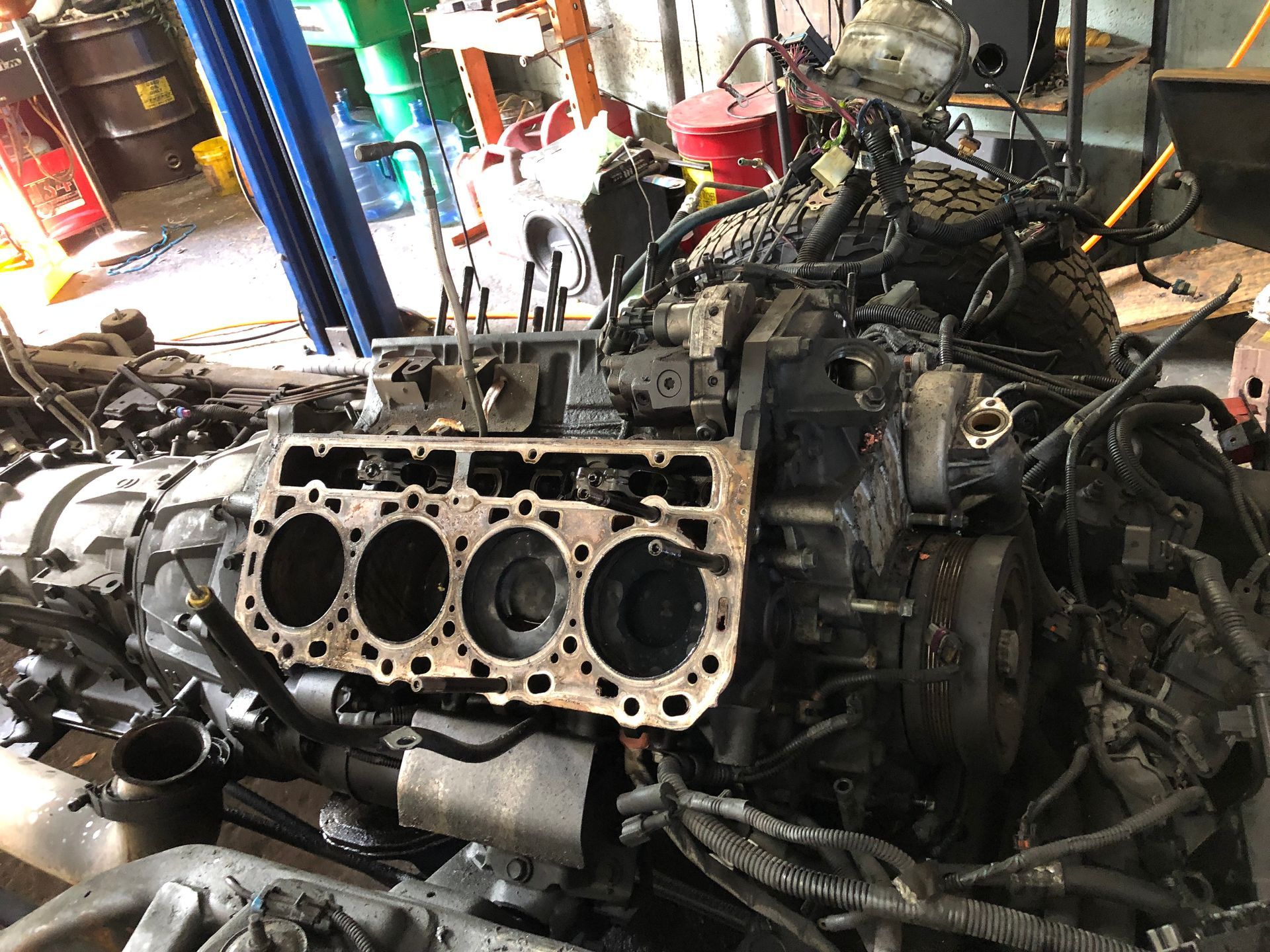 A car engine is being dismantled in a garage.