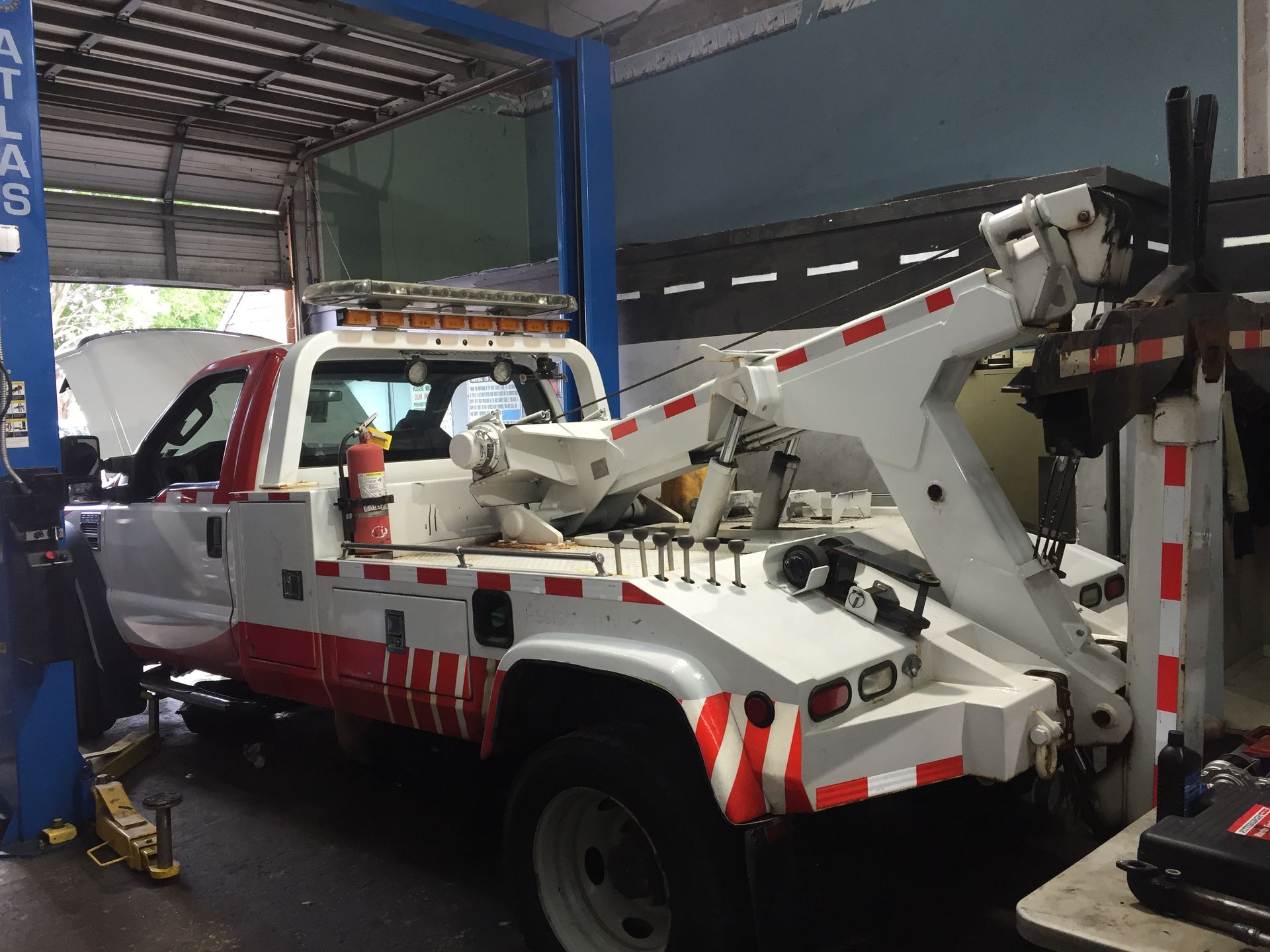 A tow truck is sitting on a lift in a garage.