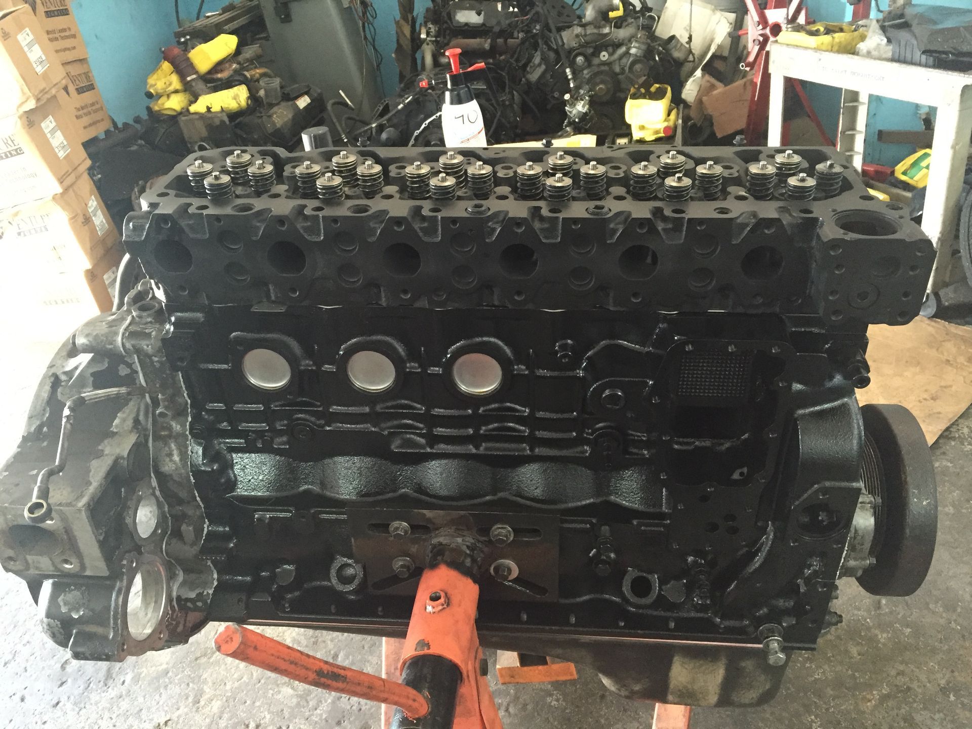 A black engine is sitting on a stand in a garage