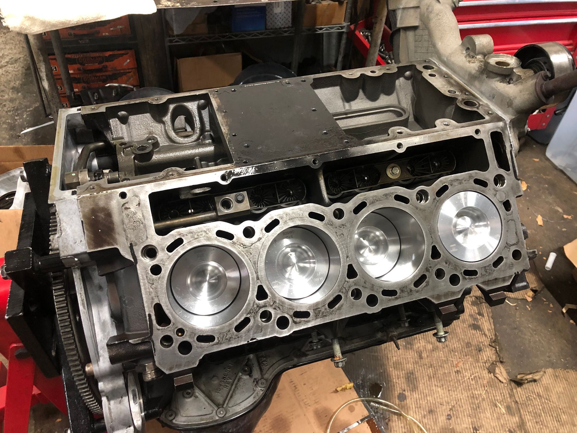 A close up of a cylinder block of a car engine in a garage.