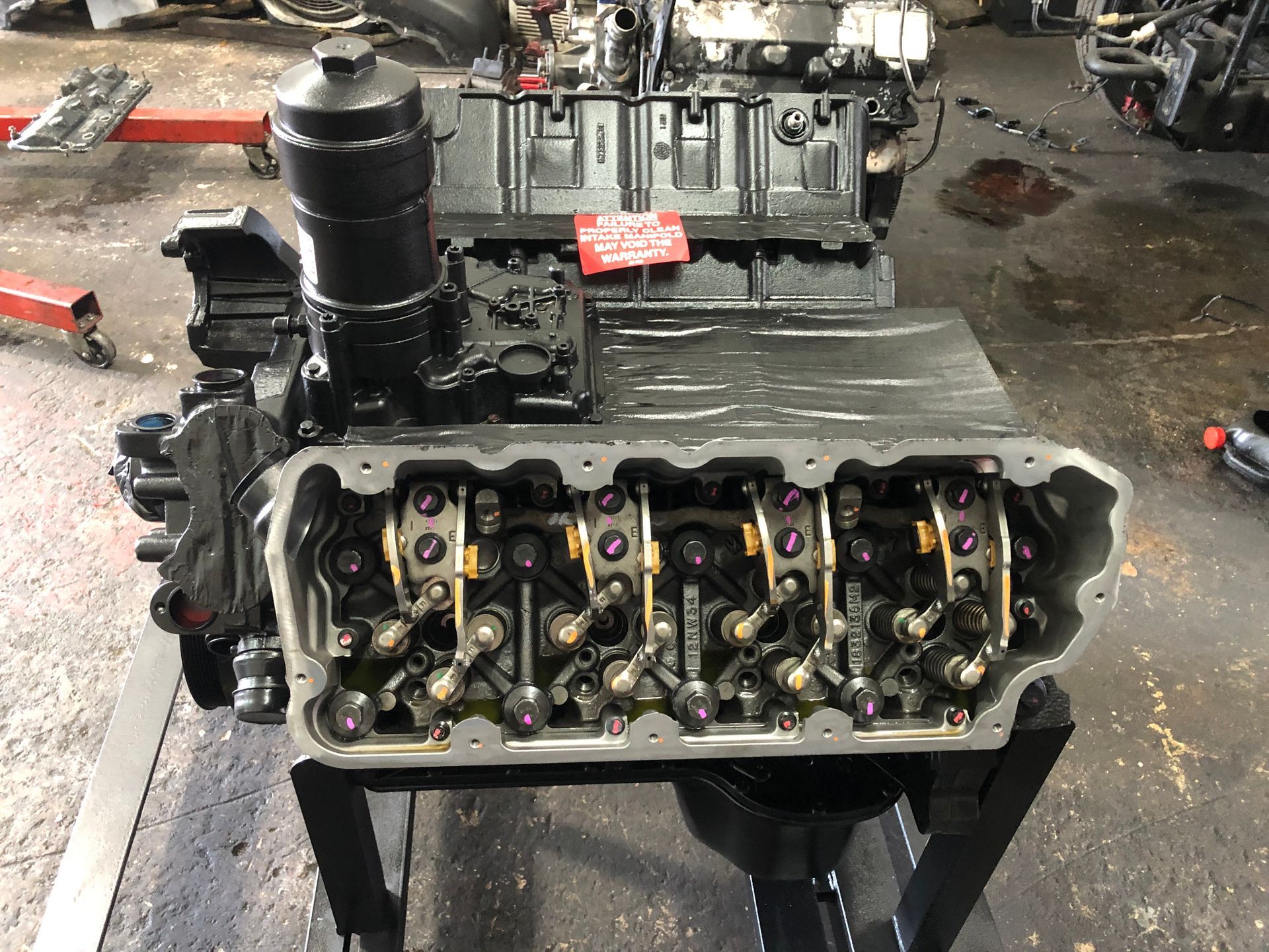 A black engine is sitting on a table in a garage.