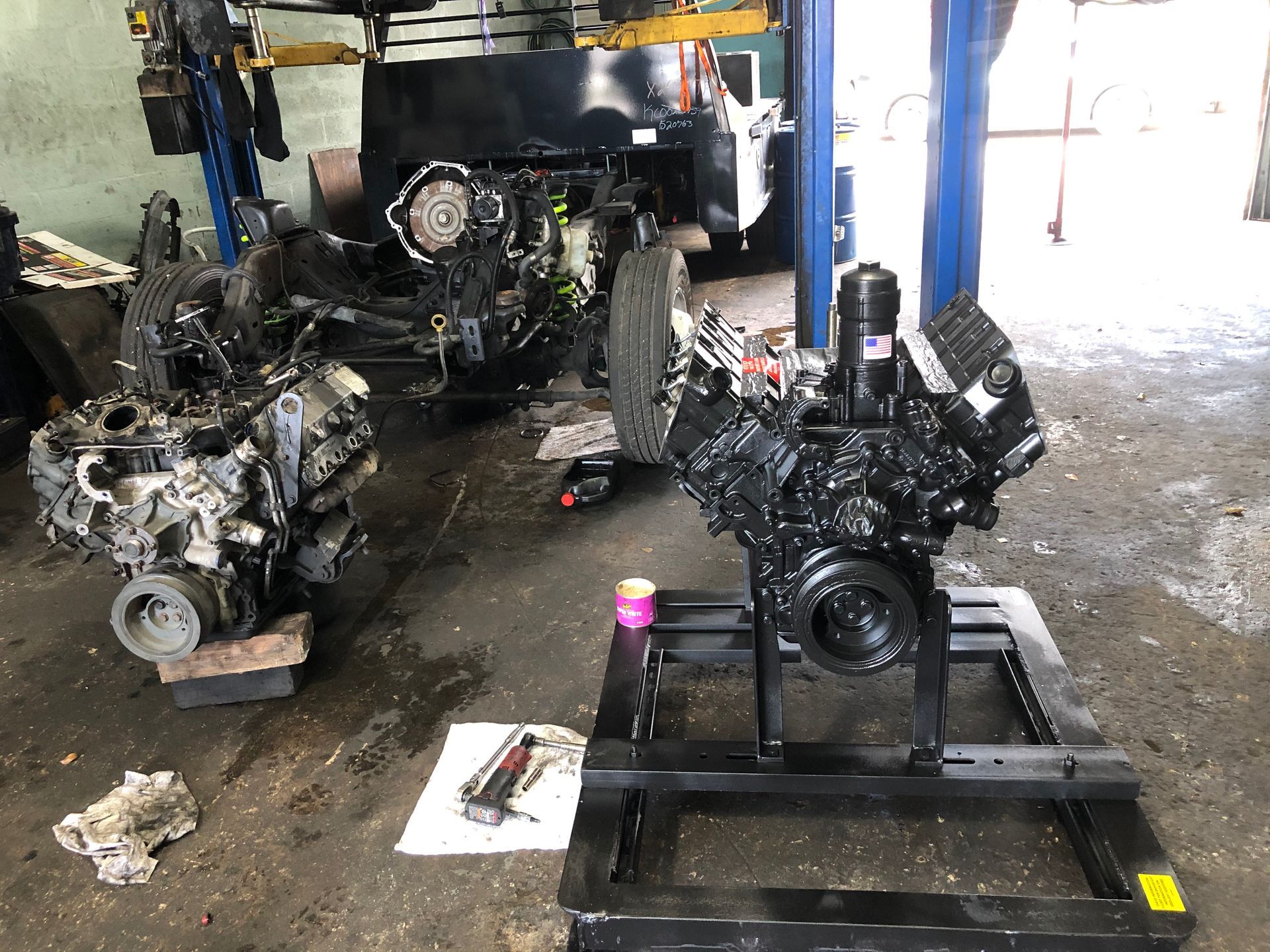 A large engine is sitting on a stand in a garage.