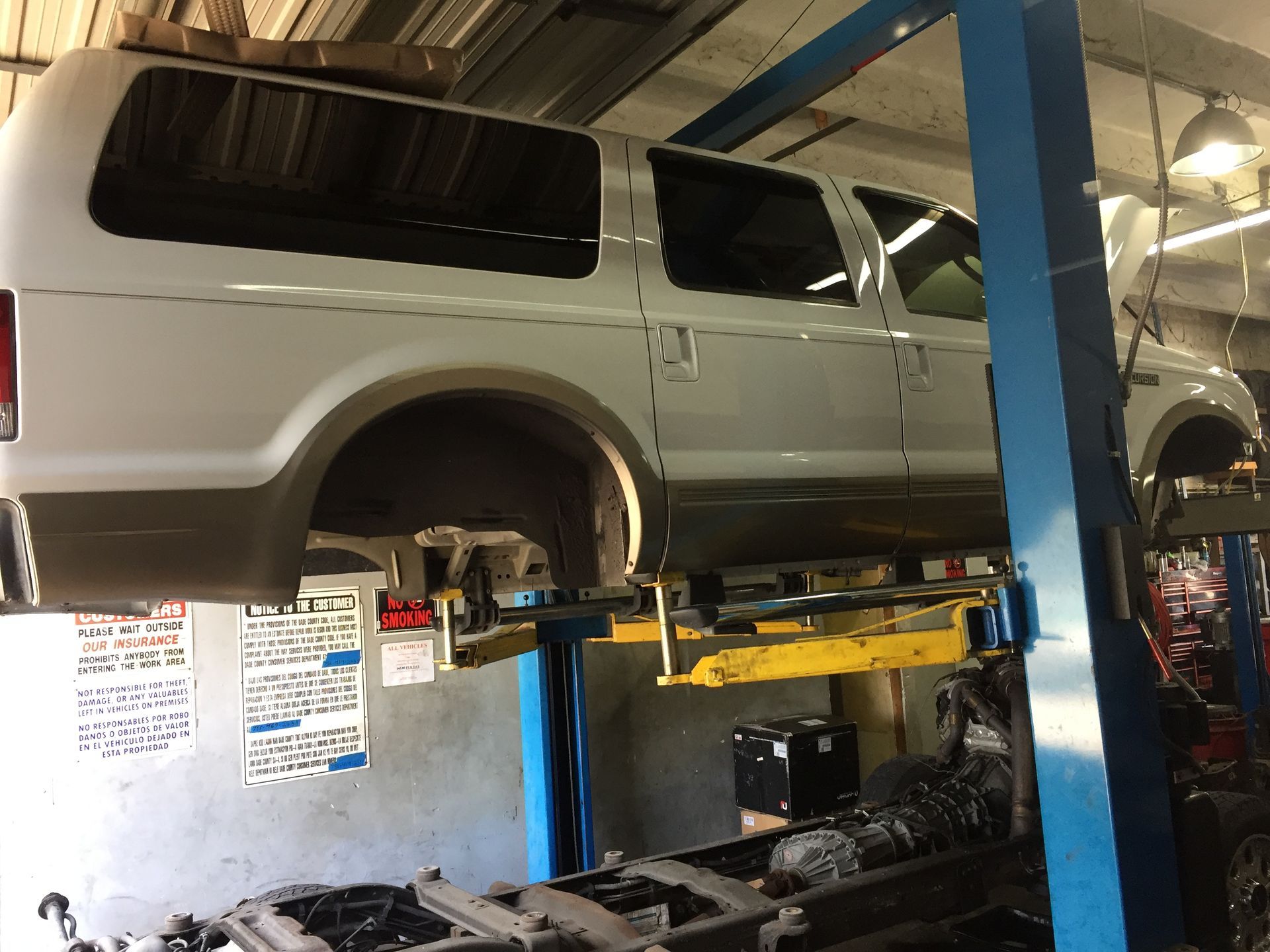 A van is sitting on a lift in a garage.