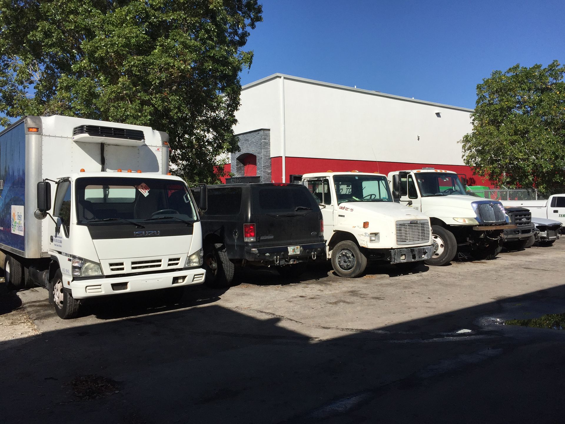 A row of trucks are parked in front of a building.