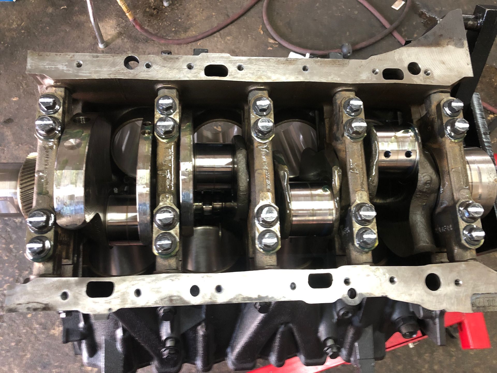 A close up of a crankshaft of a car engine in a garage.