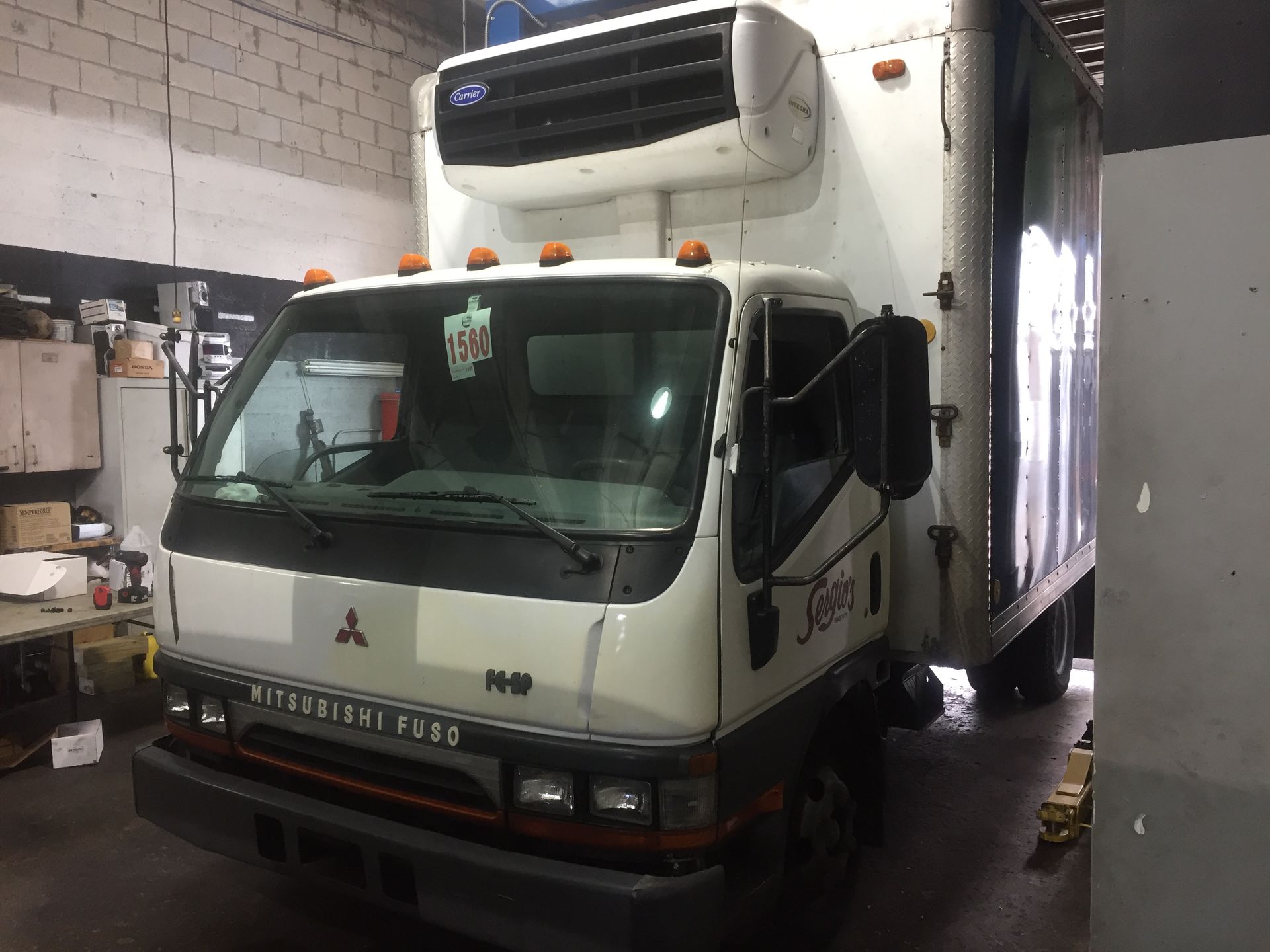 A white mitsubishi truck is parked in a garage.