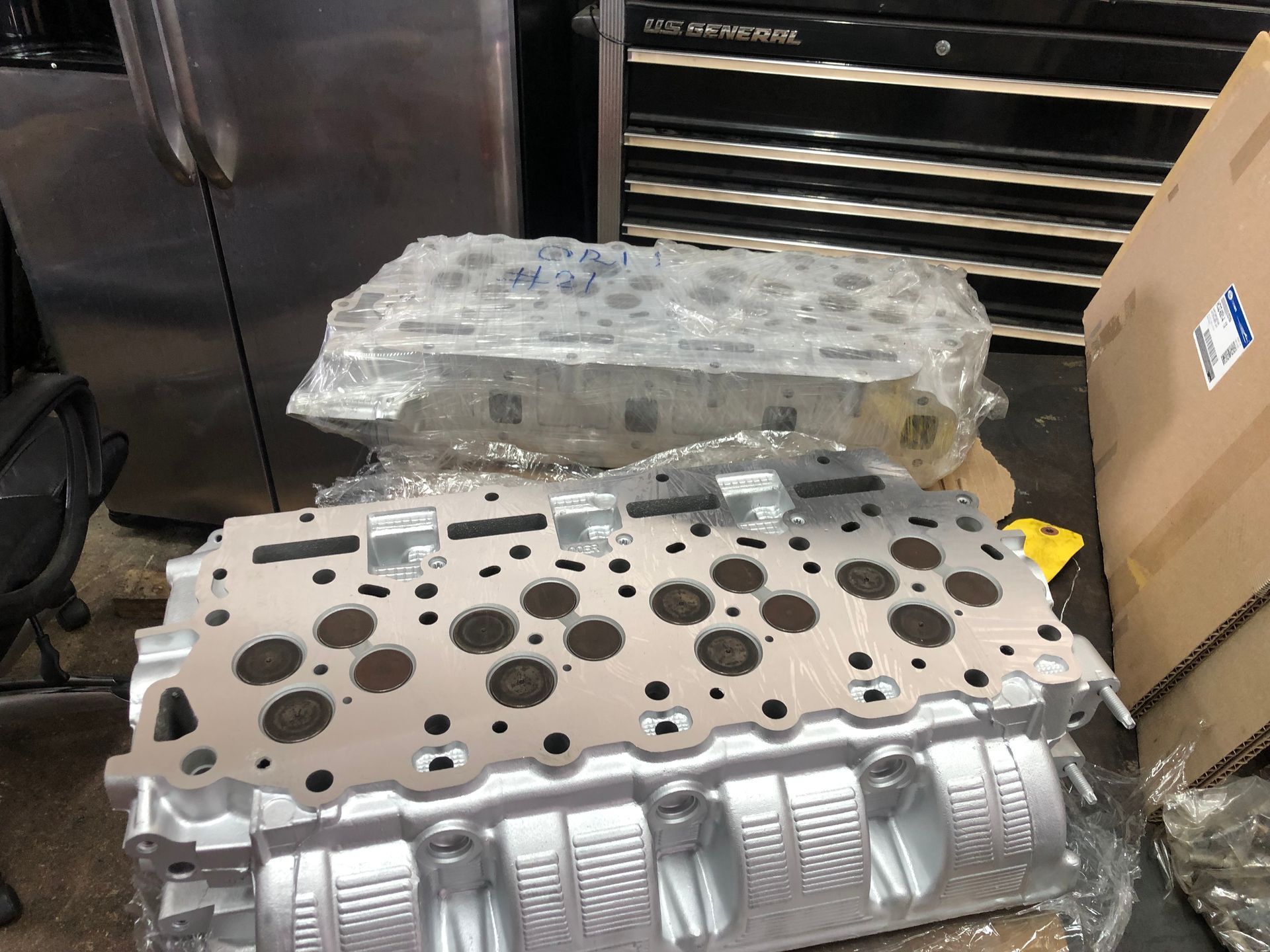 Two cylinder heads are sitting on top of each other on a table.