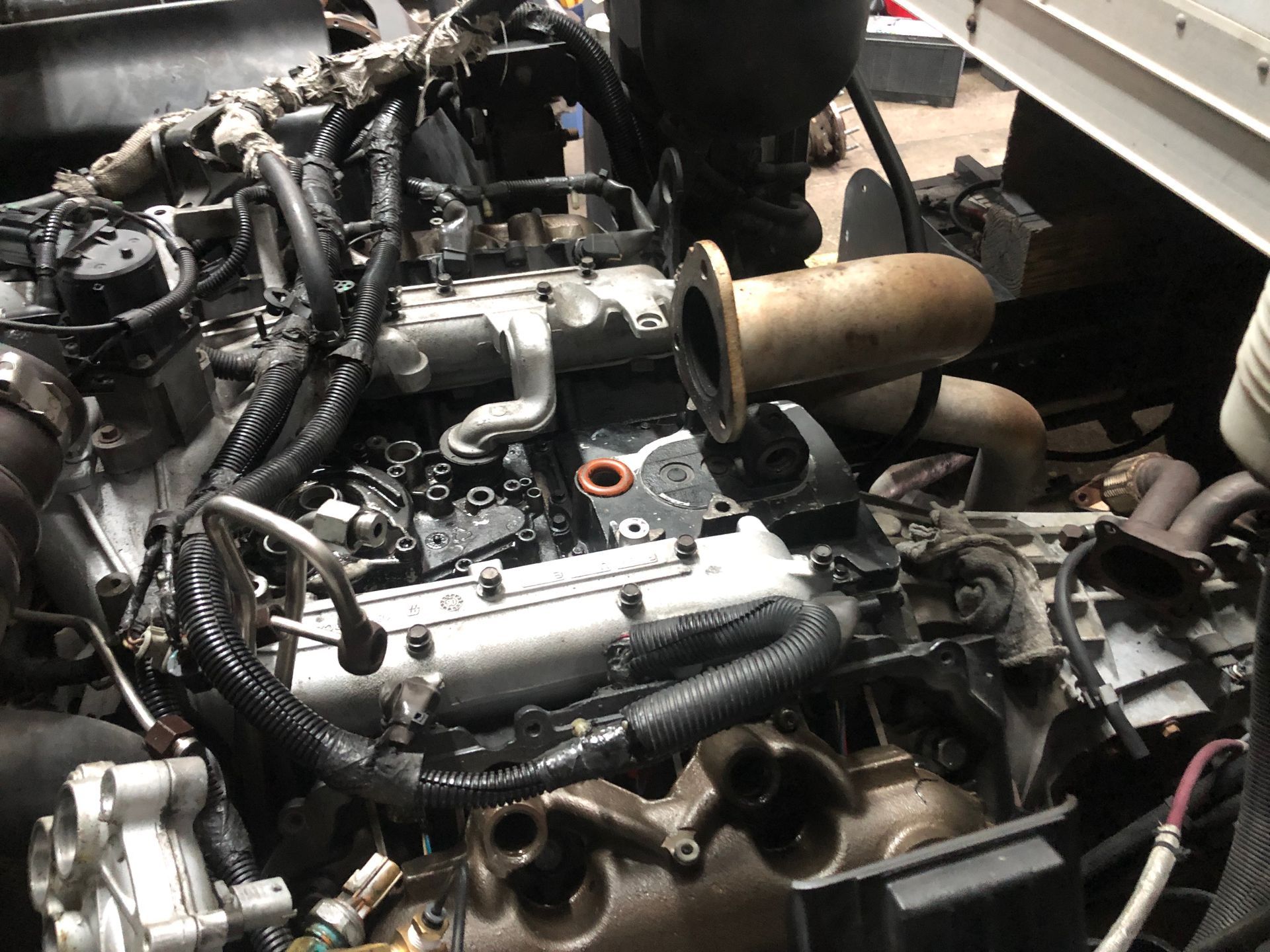 A close up of a car engine with a lot of wires coming out of it.