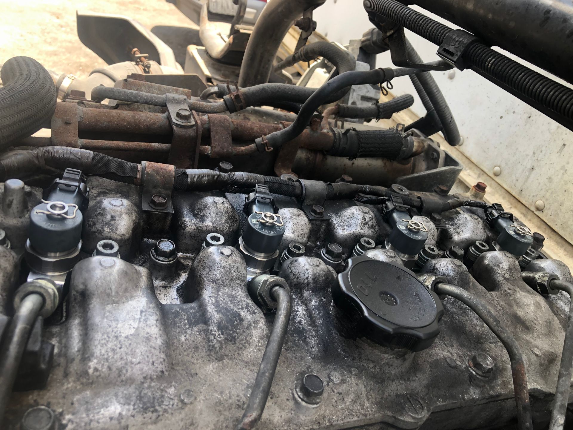 A close up of a rusty engine with a hose coming out of it