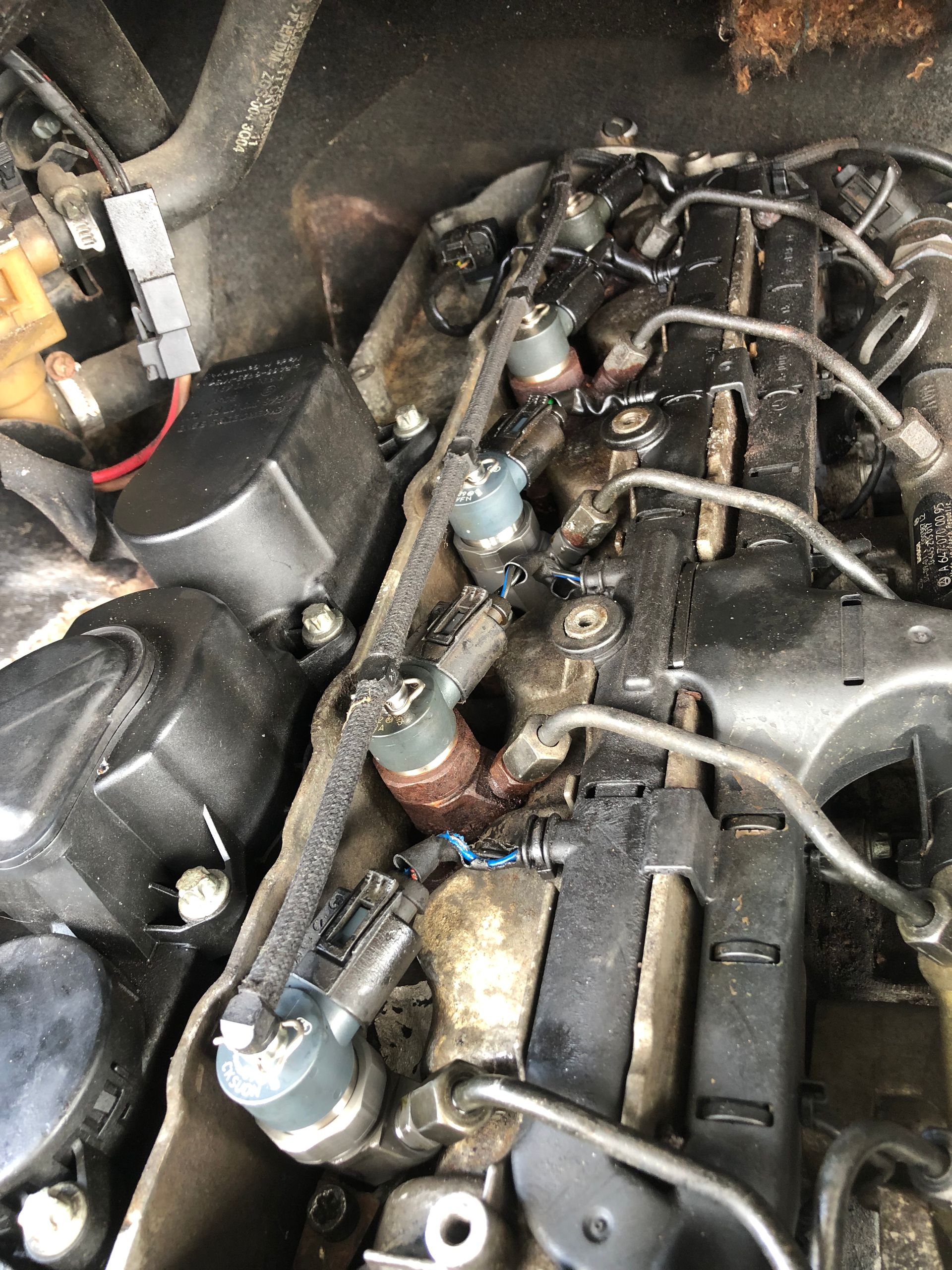 A close up of a car engine with a lot of wires coming out of it.