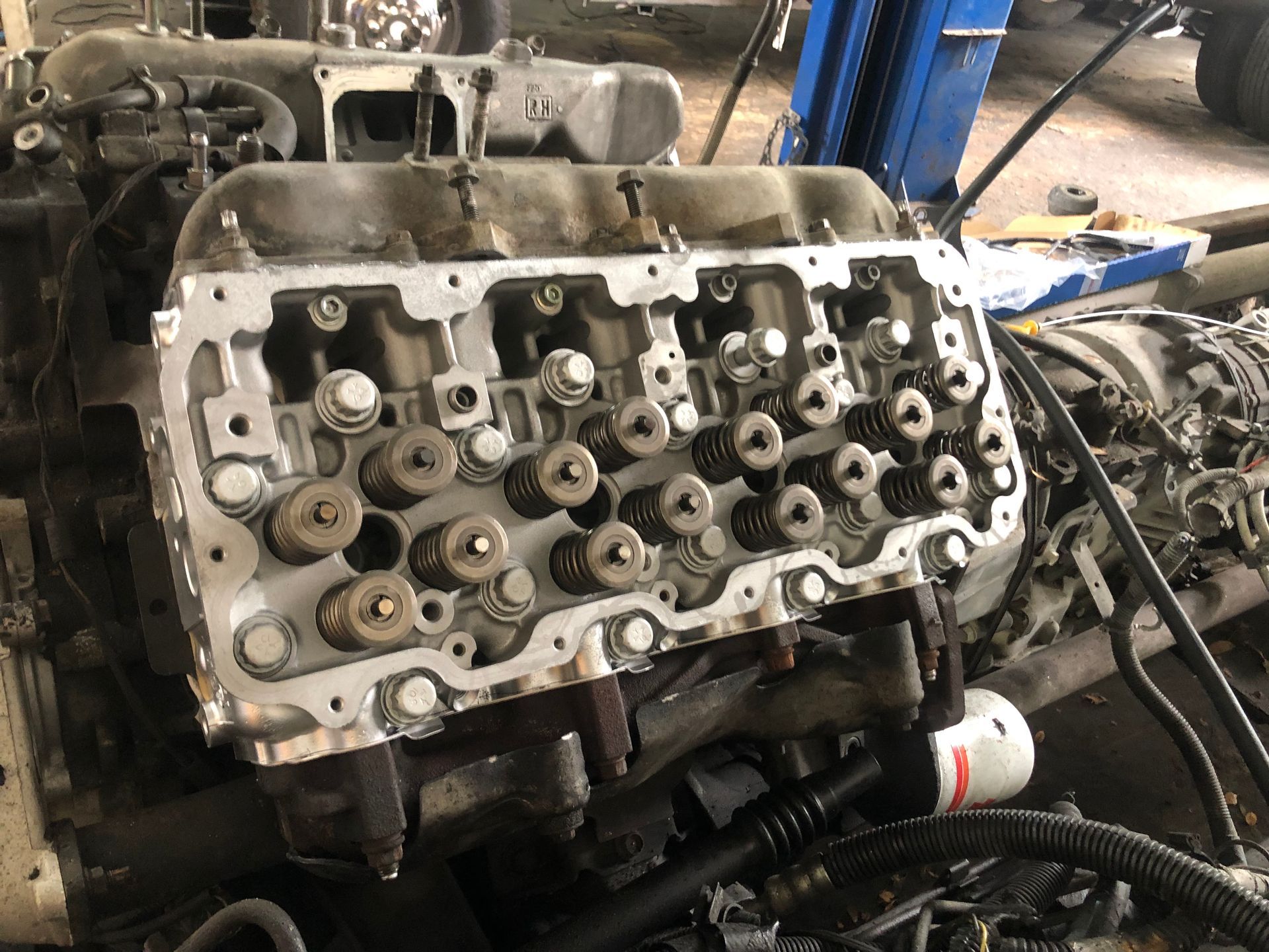 A close up of a car engine being worked on in a garage.