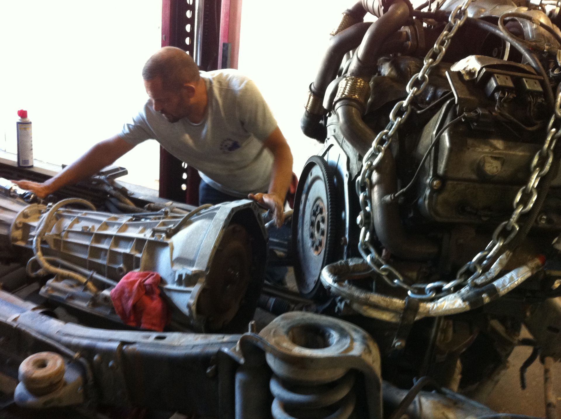 A man is working on a car engine in a garage