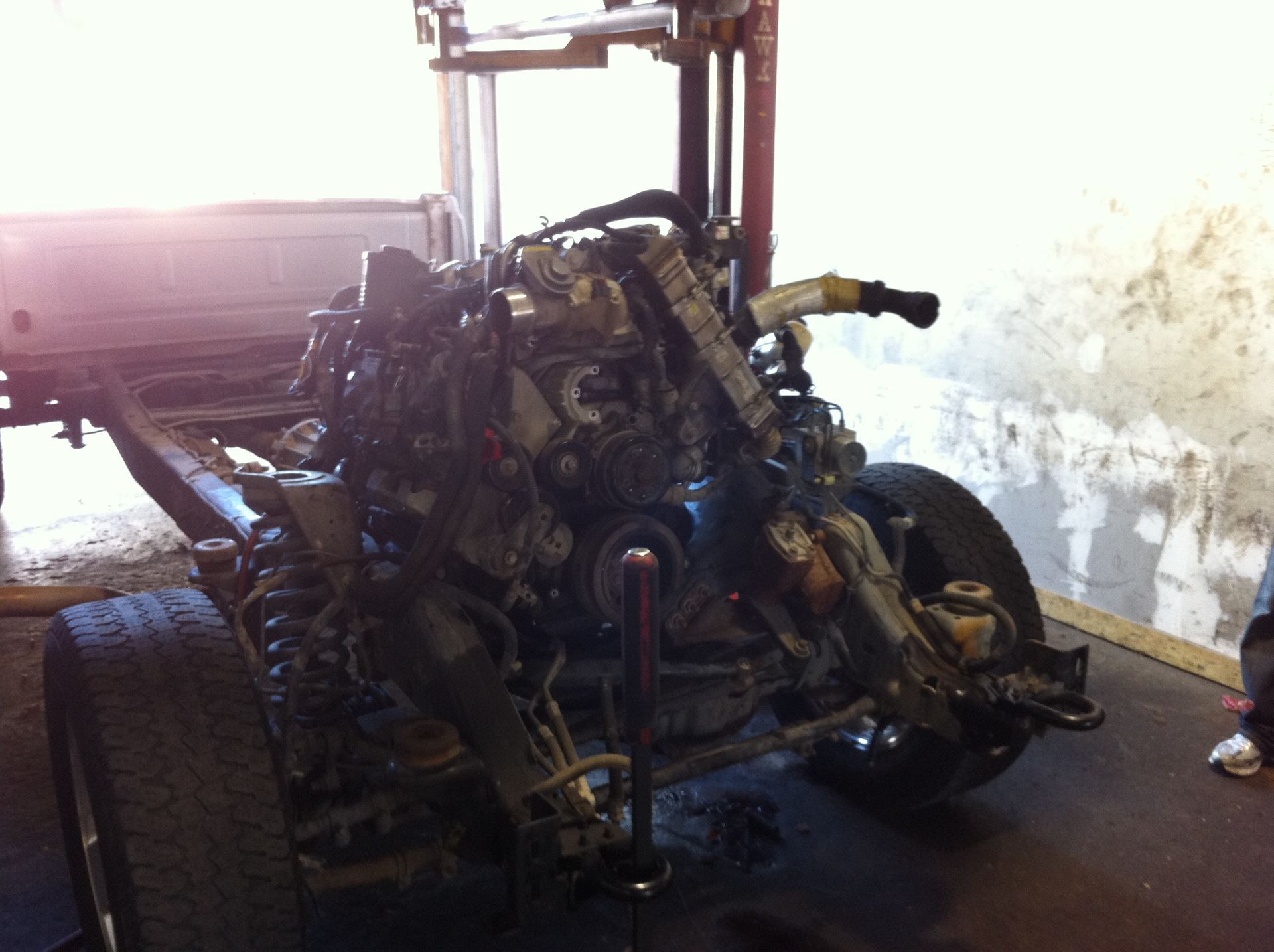 A motorcycle engine is sitting on the ground in a garage