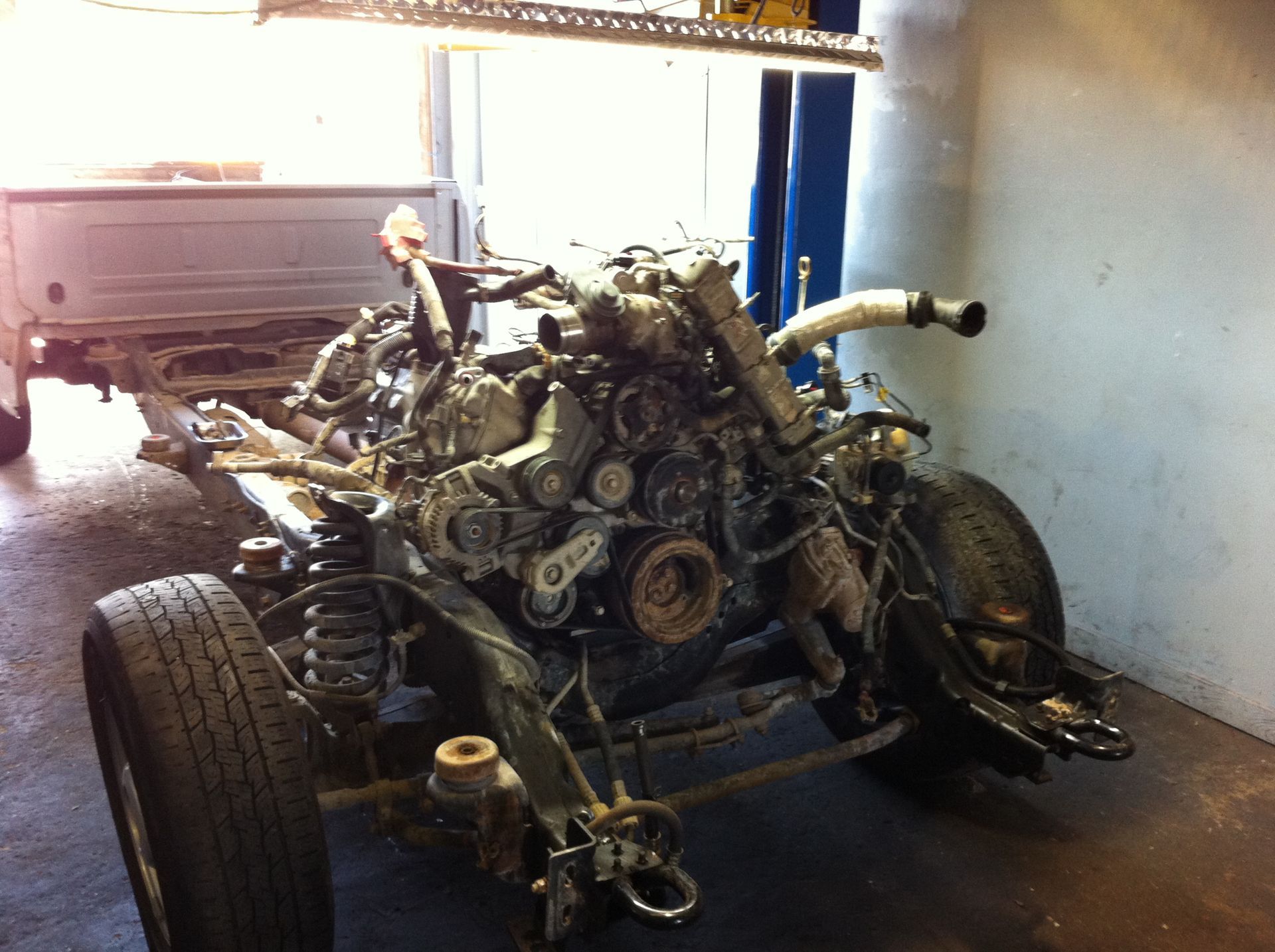 A car engine is sitting on the ground in a garage