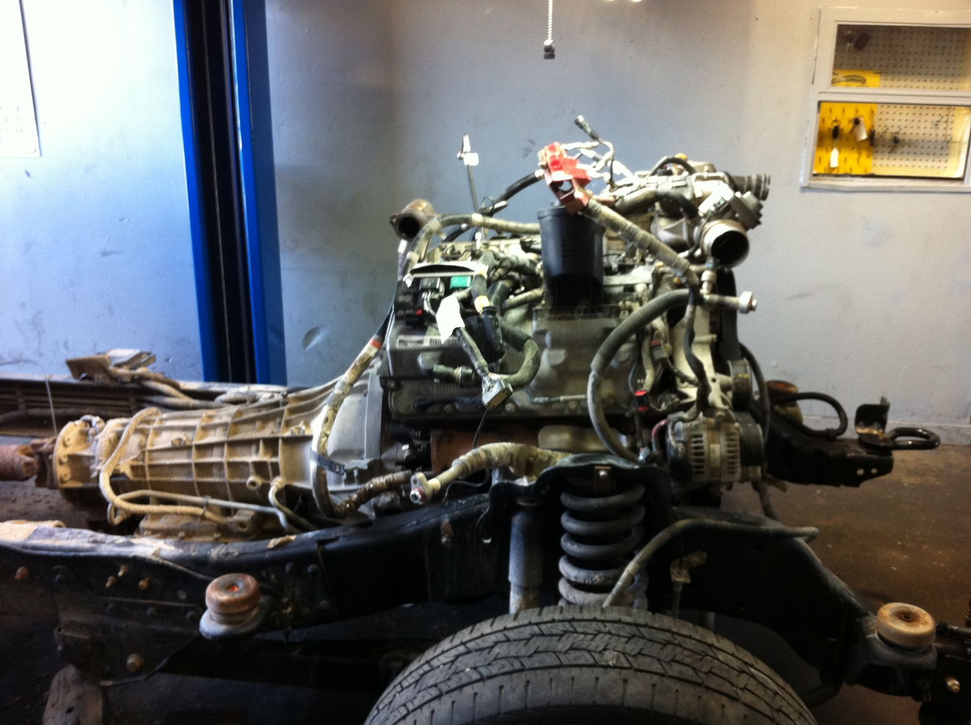 A car engine is being disassembled in a garage