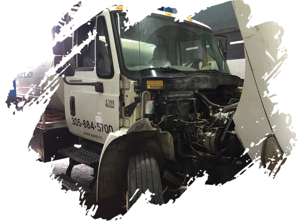 A white truck with the hood open is sitting in a garage.