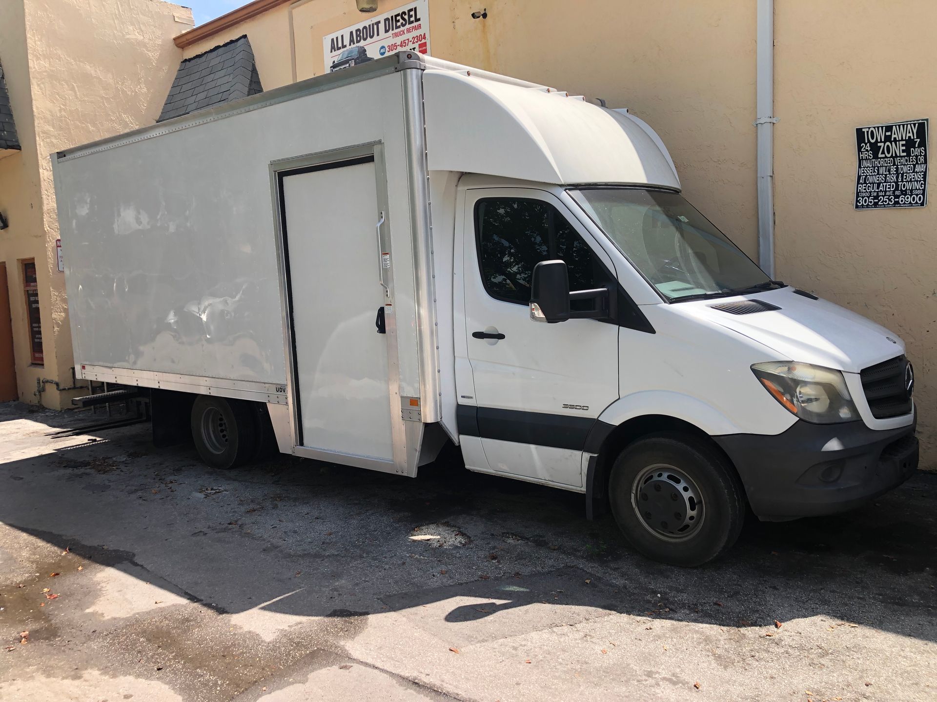 A white van is parked in front of a building.