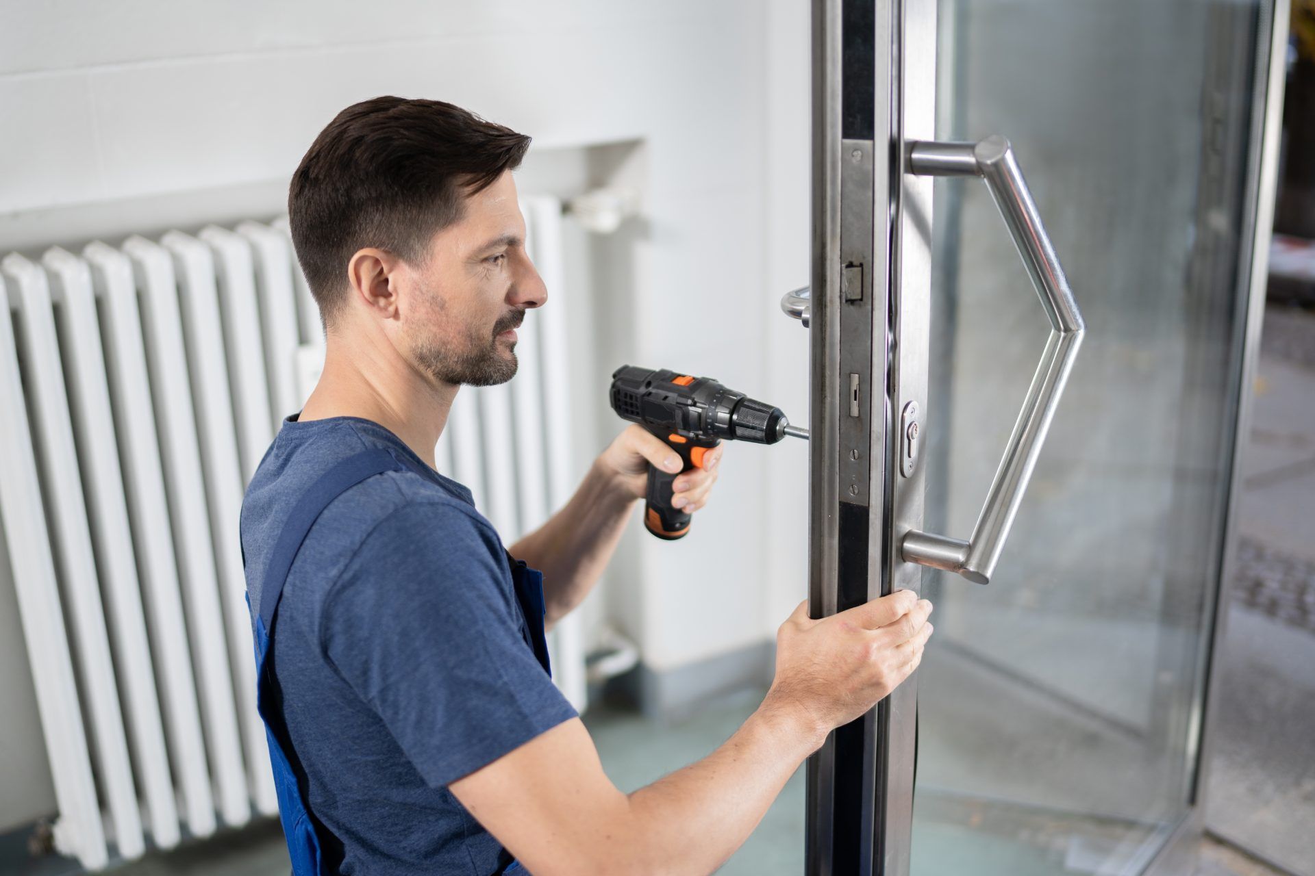 A man is fixing a door with a drill.