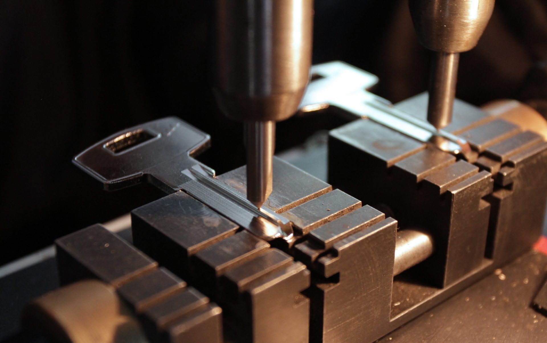A close up of a key being cut on a machine.