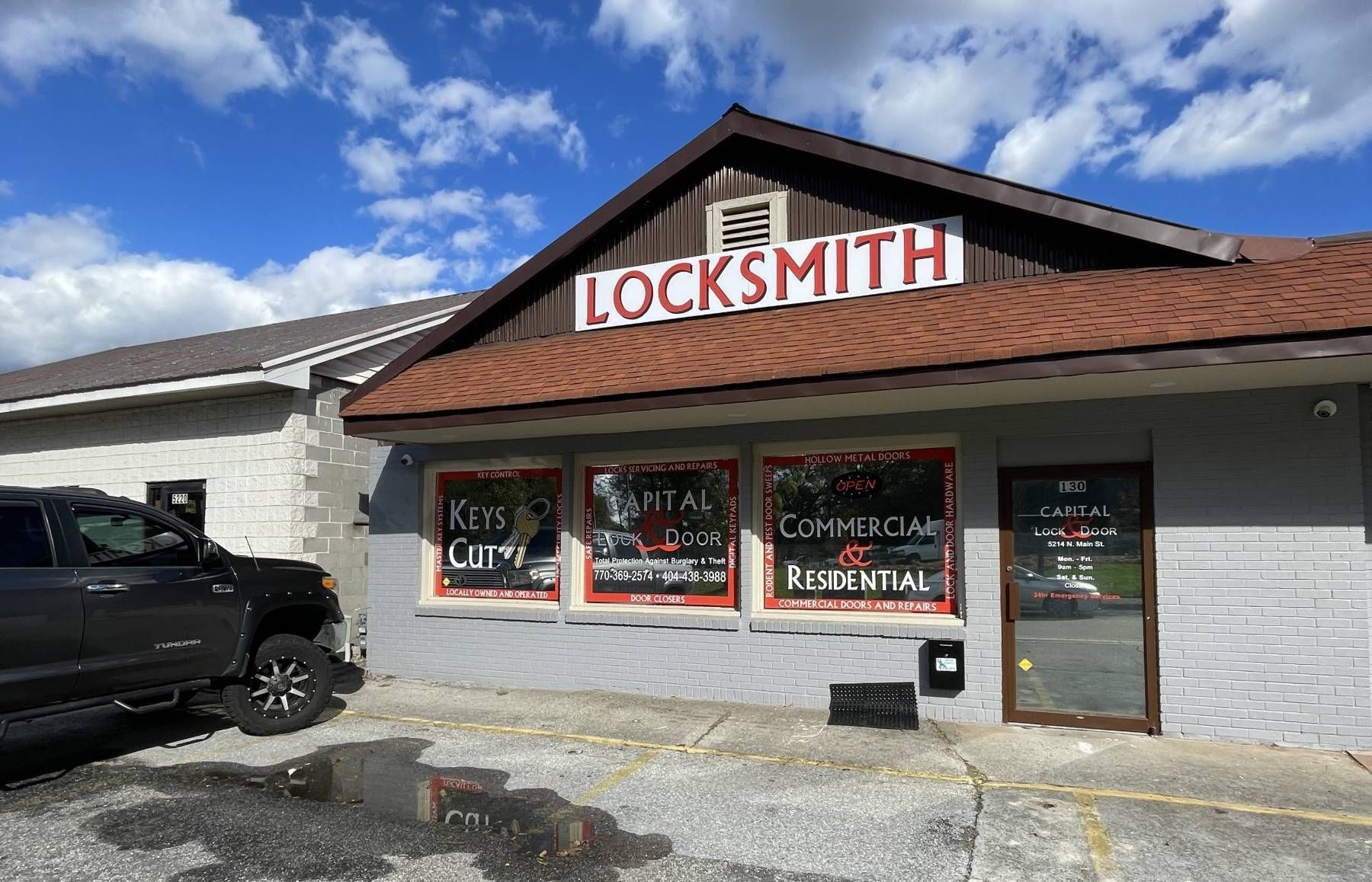 A truck is parked in front of a locksmith shop.