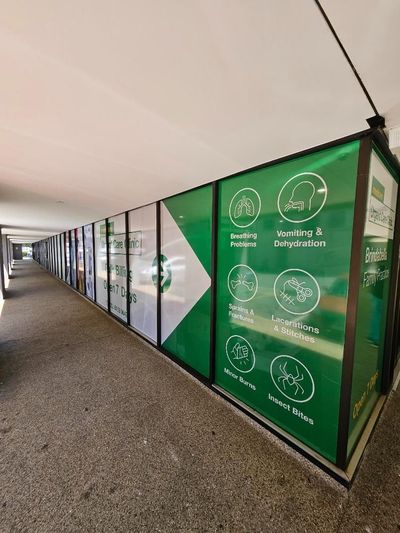 A Long Hallway With a Lot of Green Signs on the Walls — Signworld In Mitchell, ACT