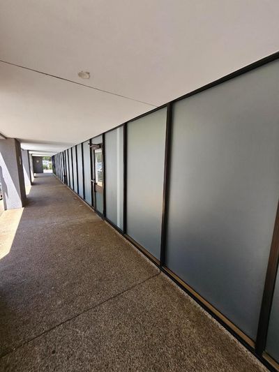 A Long Hallway With a Lot of Windows and Doors in a Building — Signworld In Mitchell, ACT
