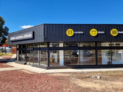 A large black building with a lot of windows and a sign that says t on it — Signworld In Mitchell, ACT