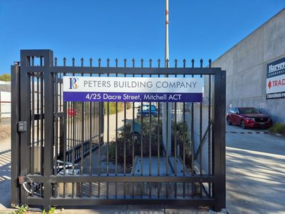 A Fence With a Sign That Says Peter's Building Company — Signworld In Mitchell, ACT
