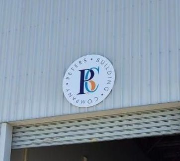 A Car is Parked in Front of a Building With a Garage Door Open — Signworld In Mitchell, ACT