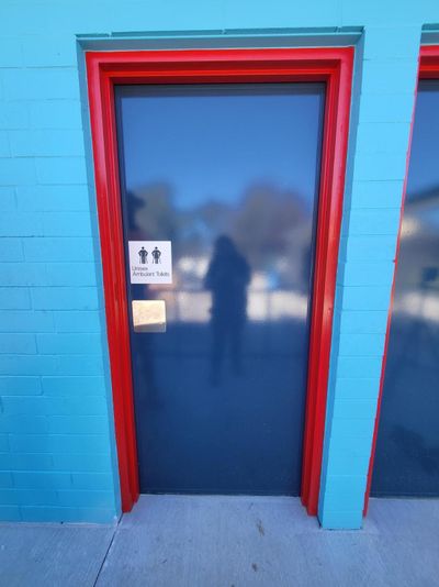 A Blue Brick Building With a Black Door and a Red Trim — Signworld In Mitchell, ACT