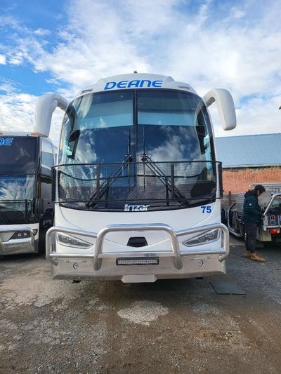 A White Bus is Parked in a Parking Lot Next to Another Bus — Signworld In Mitchell, ACT