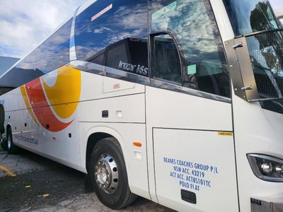 A White and Yellow Bus is Parked on the Side of the Road — Signworld In Mitchell, ACT